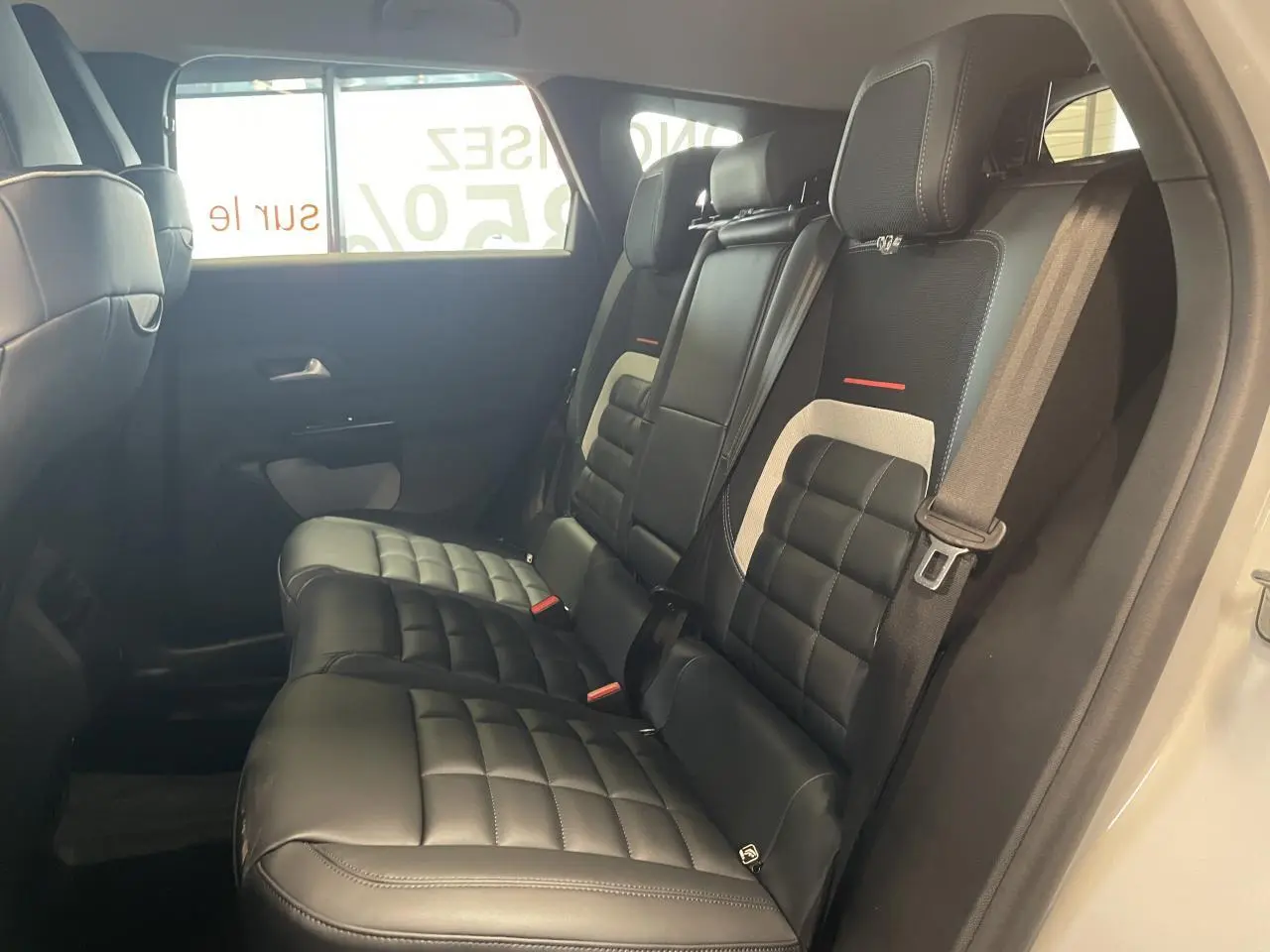 Vue latérale intérieure des sièges arrière noirs matelassés du Citroën C5 Aircross 2026 avec ceinture de sécurité visible.
