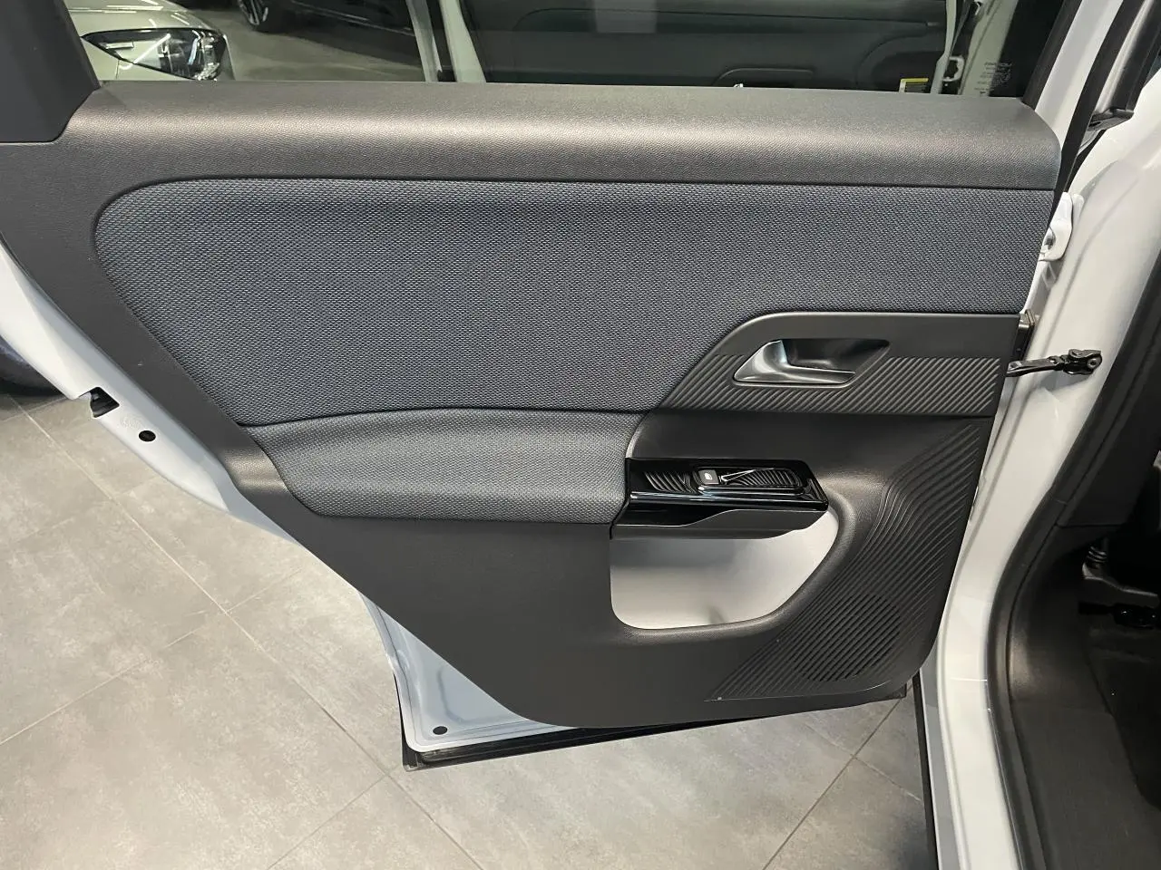 Vue intérieure de la porte arrière droite blanche du Citroën C5 Aircross 2026 avec habillage noir et gris texturé.
