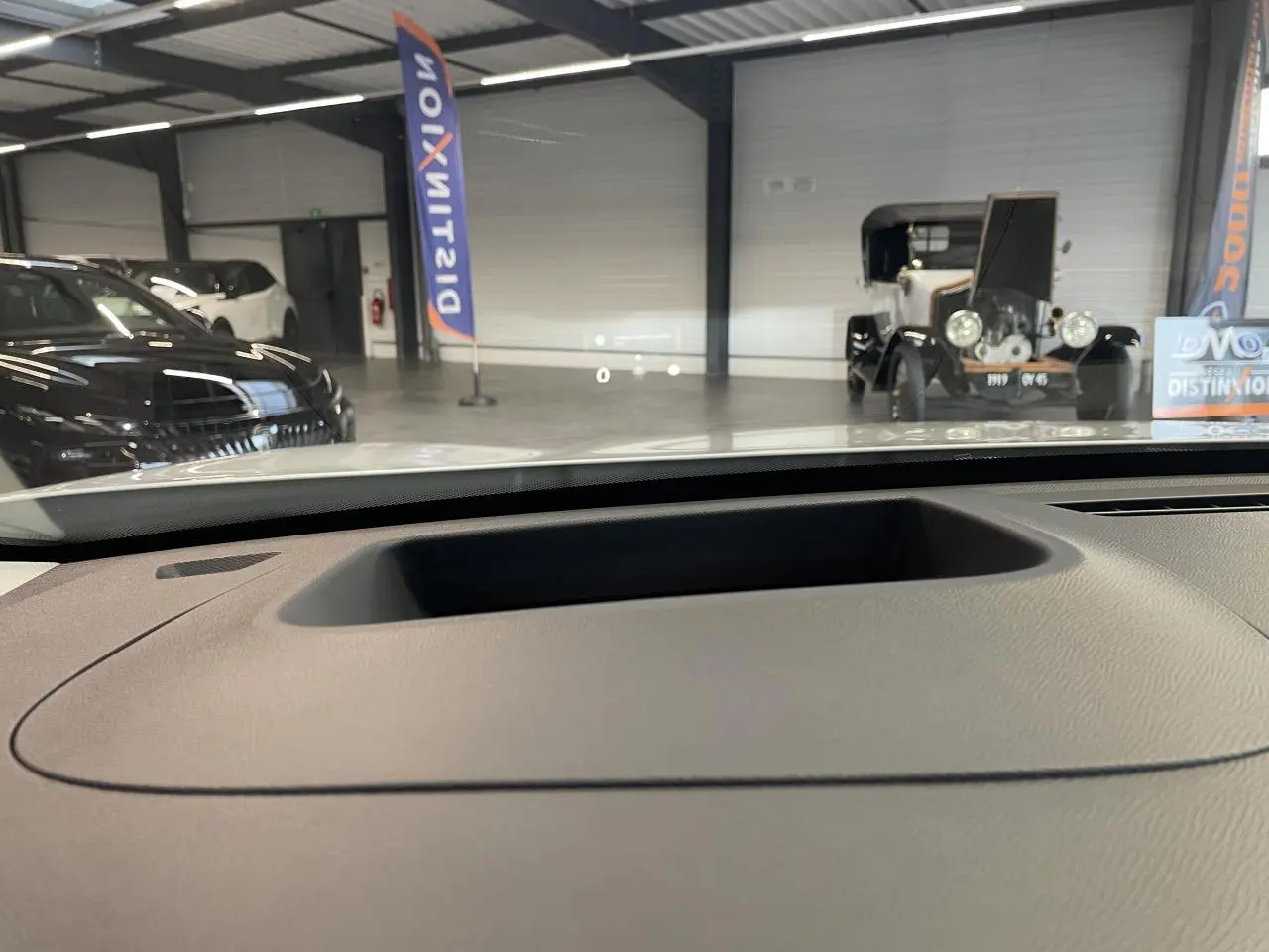 Vue intérieure depuis le tableau de bord d'un Citroën C5 Aircross blanc, avec projection tête haute visible sur le pare-brise.