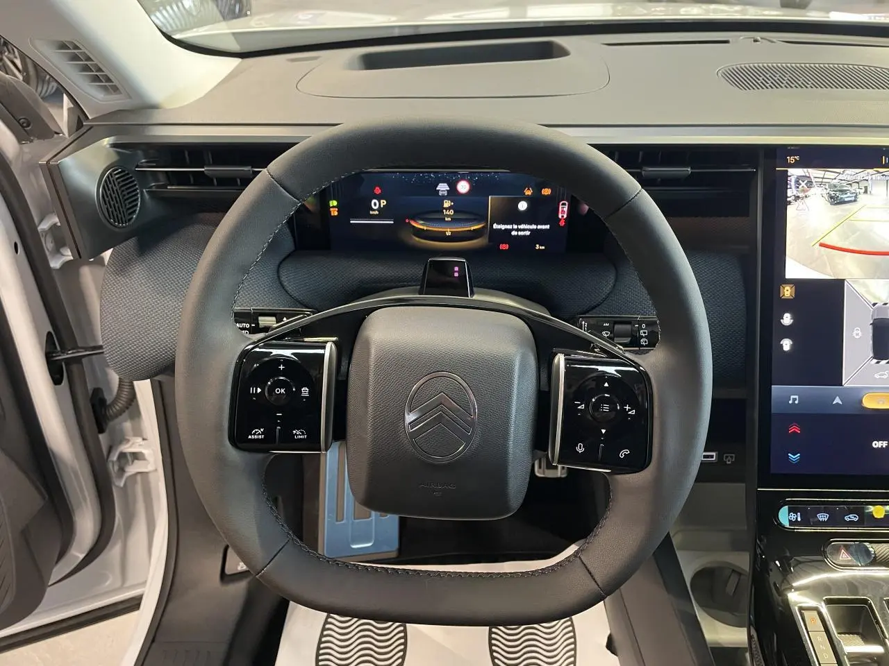 Vue intérieure centrée sur le volant noir multifonctions du Citroën C5 Aircross 2026 avec tableau de bord numérique et écran tactile.