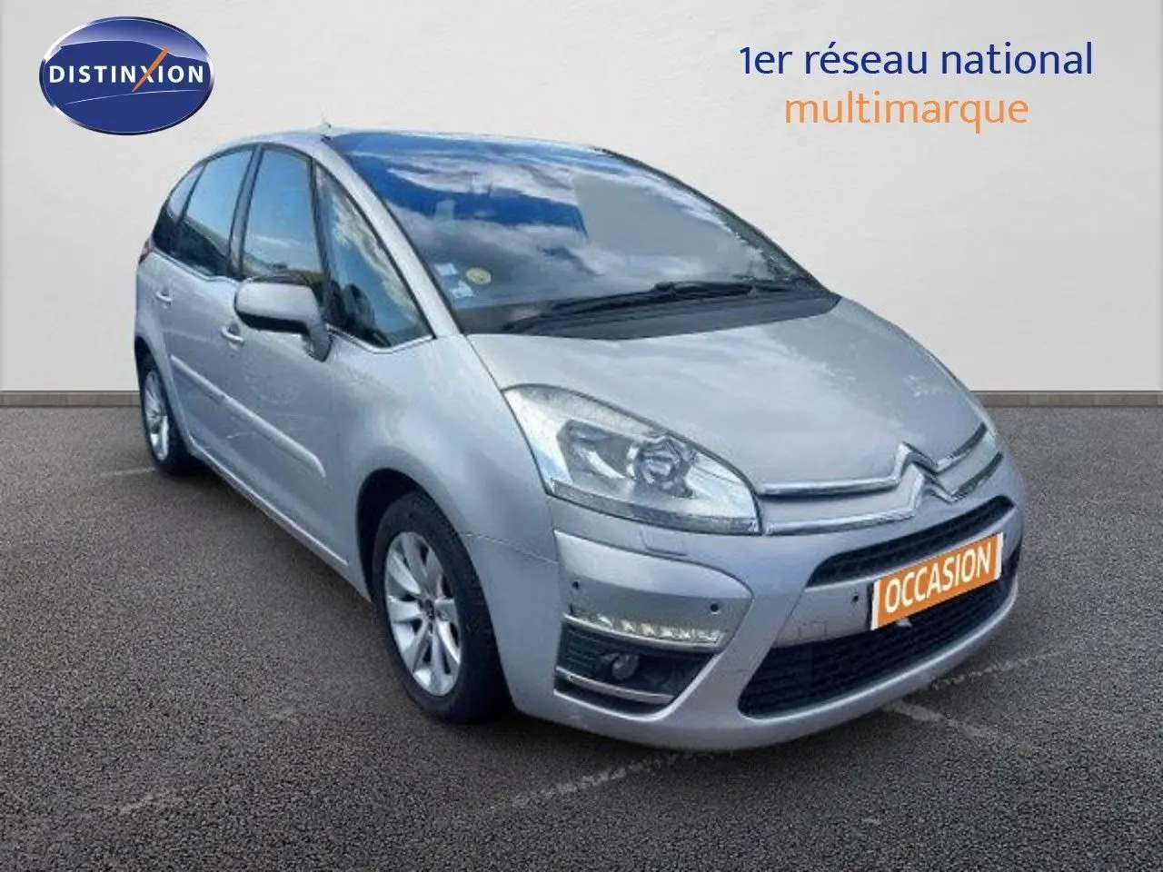 Vue 3/4 avant d'une Citroën C4 Picasso gris alu métallisé avec feux LED et calandre distinctive.