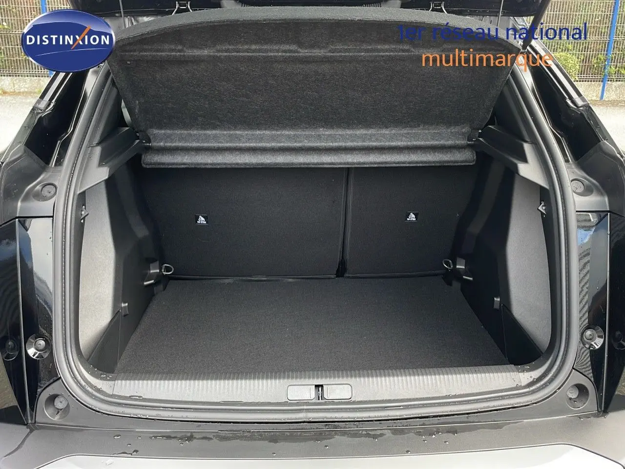 Coffre ouvert du Peugeot 2008 noir perla metal, vue arrière montrant l'espace de chargement vide et propre.