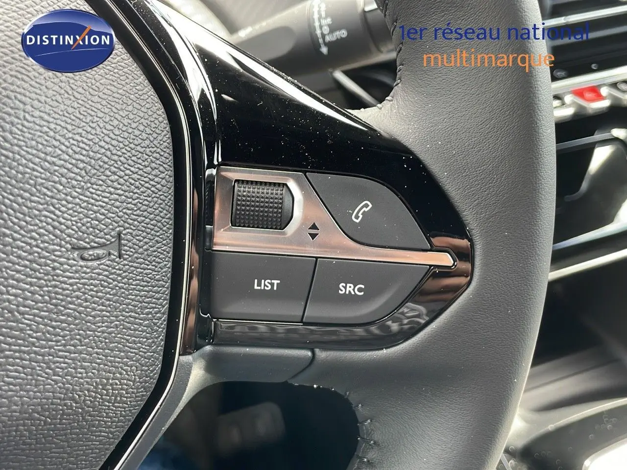 Gros plan sur les commandes gauche du volant cuir noir du Peugeot 2008 2025, avec boutons de contrôle audio et appel.