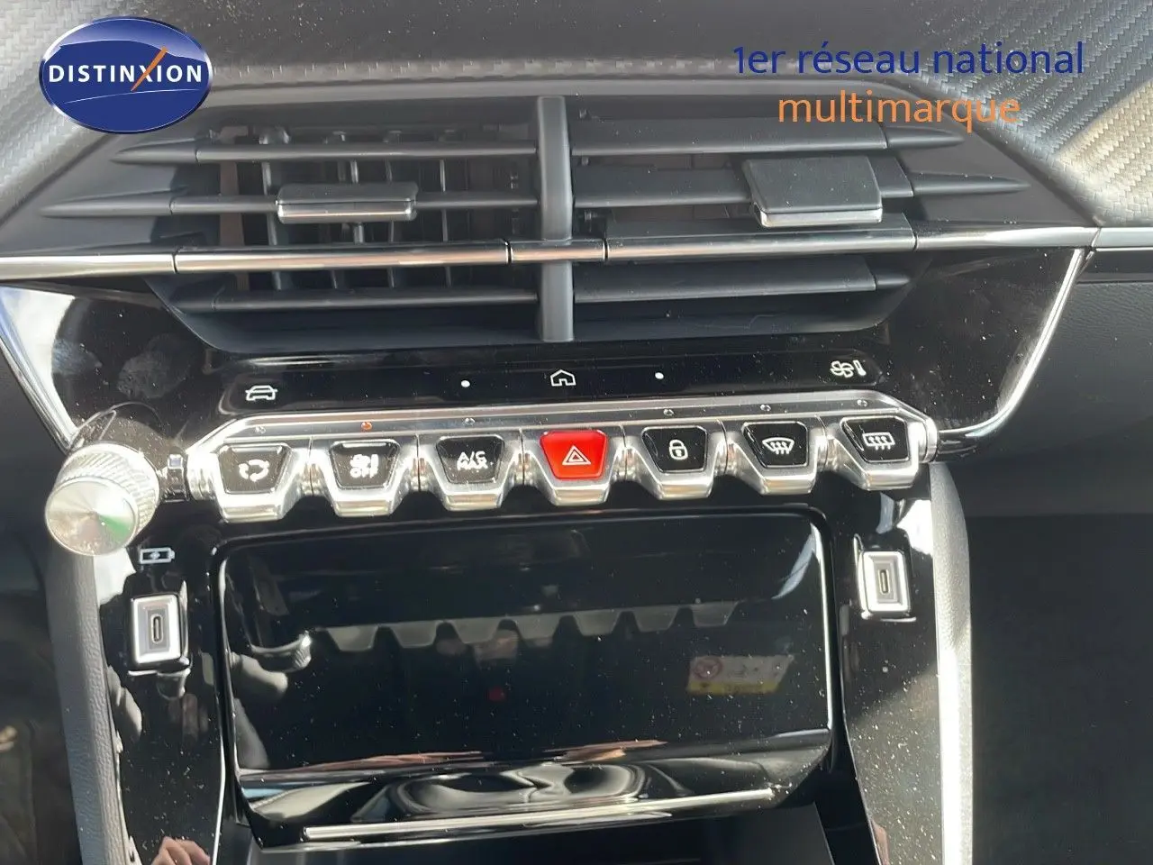 Vue rapprochée du tableau de bord noir brillant du Peugeot 2008 2025 avec commandes tactiles et aérateurs horizontaux.