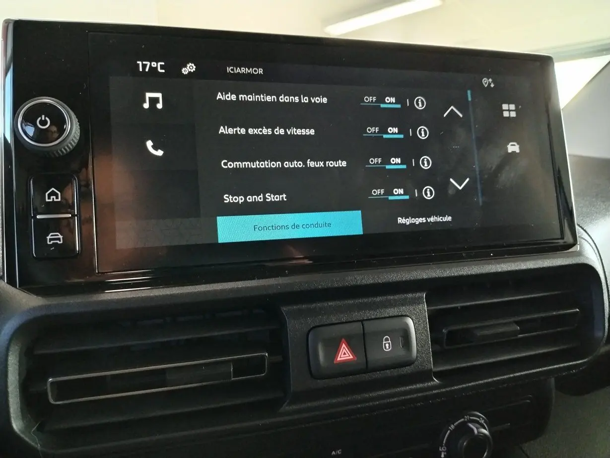 Écran tactile central du tableau de bord du Citroën Berlingo 2025 gris acier, affichant les aides à la conduite activées.