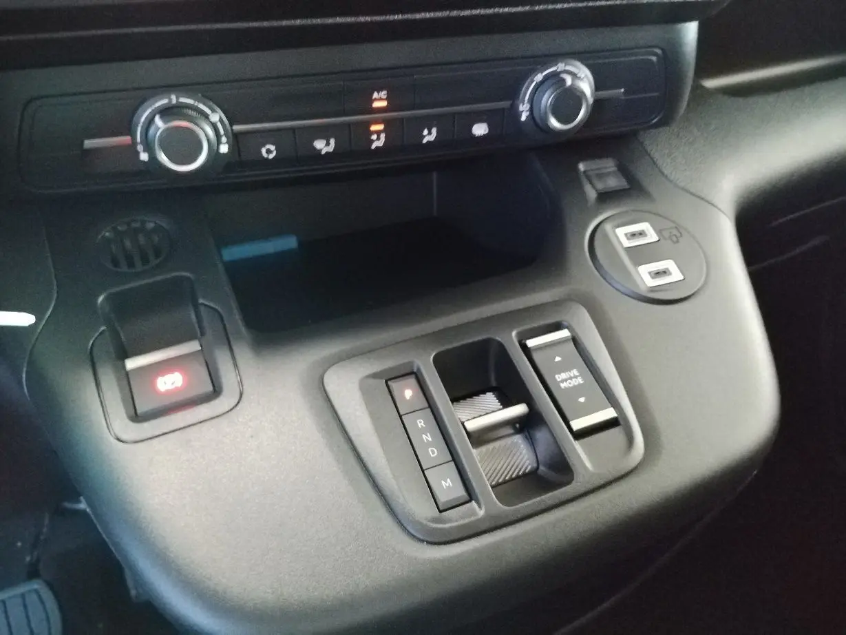 Gros plan sur la console centrale du Citroën Berlingo gris acier 2025, montrant la commande de boîte auto et les réglages climatiques.