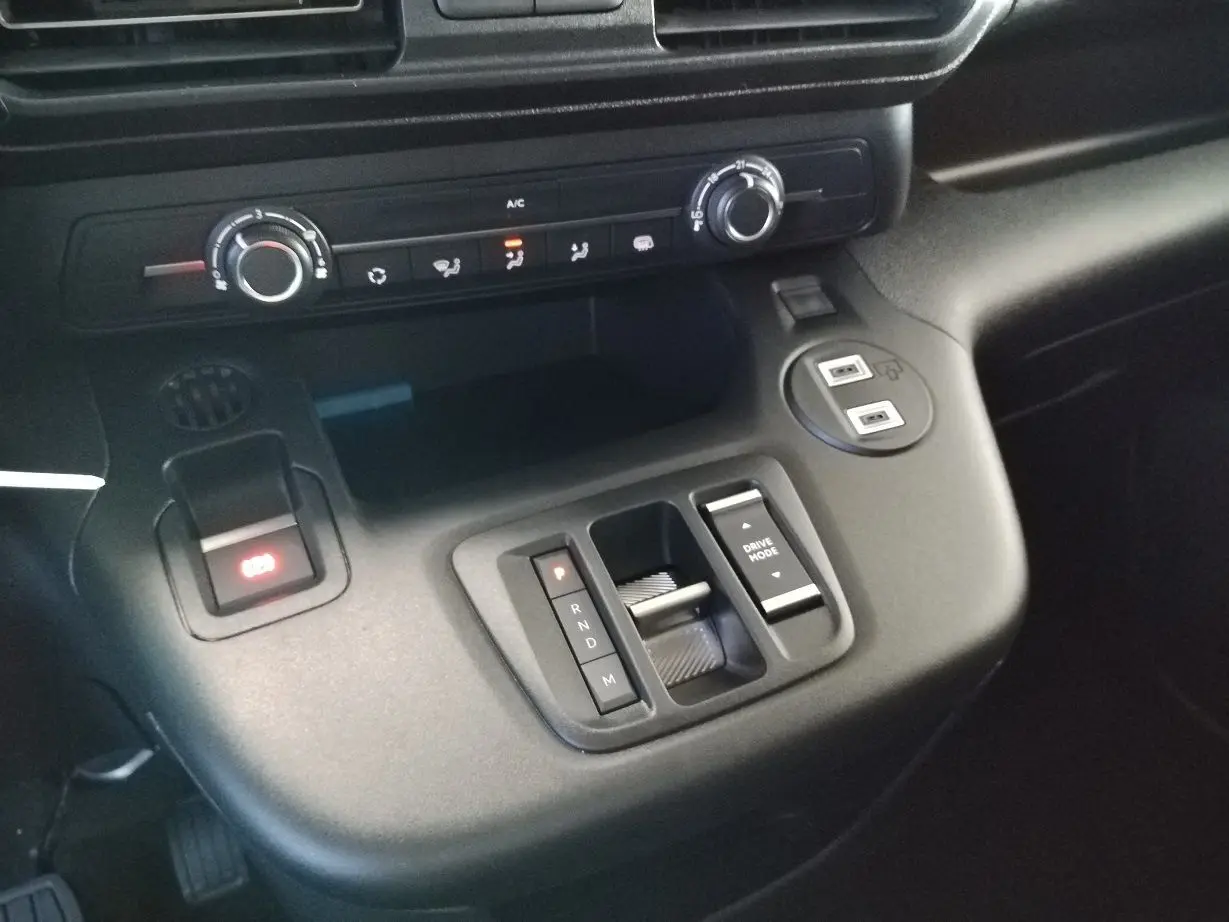 Vue rapprochée de la console centrale du Citroën Berlingo gris acier 2025, avec commandes de boîte auto et climatisation.