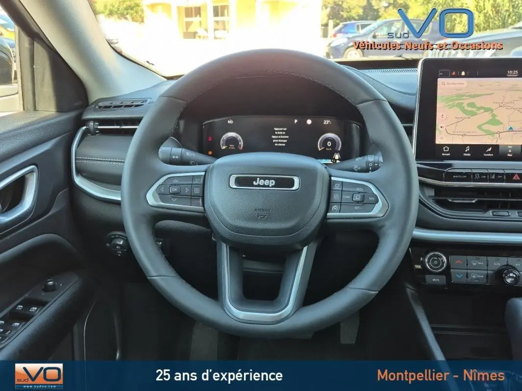 Vue intérieure centrée sur le volant noir du Jeep Compass 2023 avec tableau de bord numérique et écran tactile.