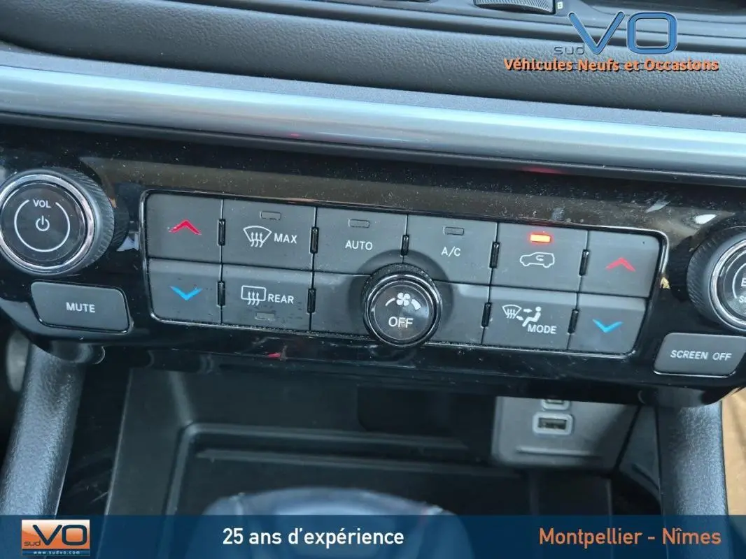 Vue rapprochée du tableau de bord noir du Jeep Compass 2023 montrant les commandes de climatisation et multimédia.