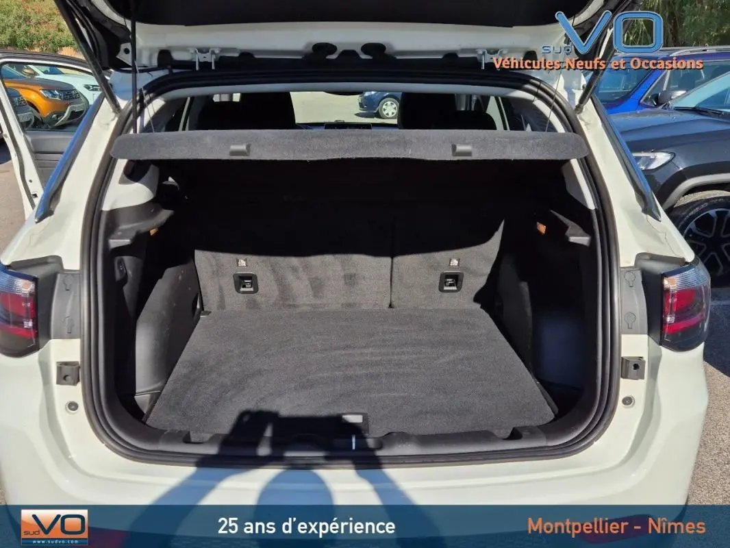 Coffre ouvert vu de l'arrière d'un Jeep Compass blanc 2023, montrant l'espace de chargement vide et la plage arrière.