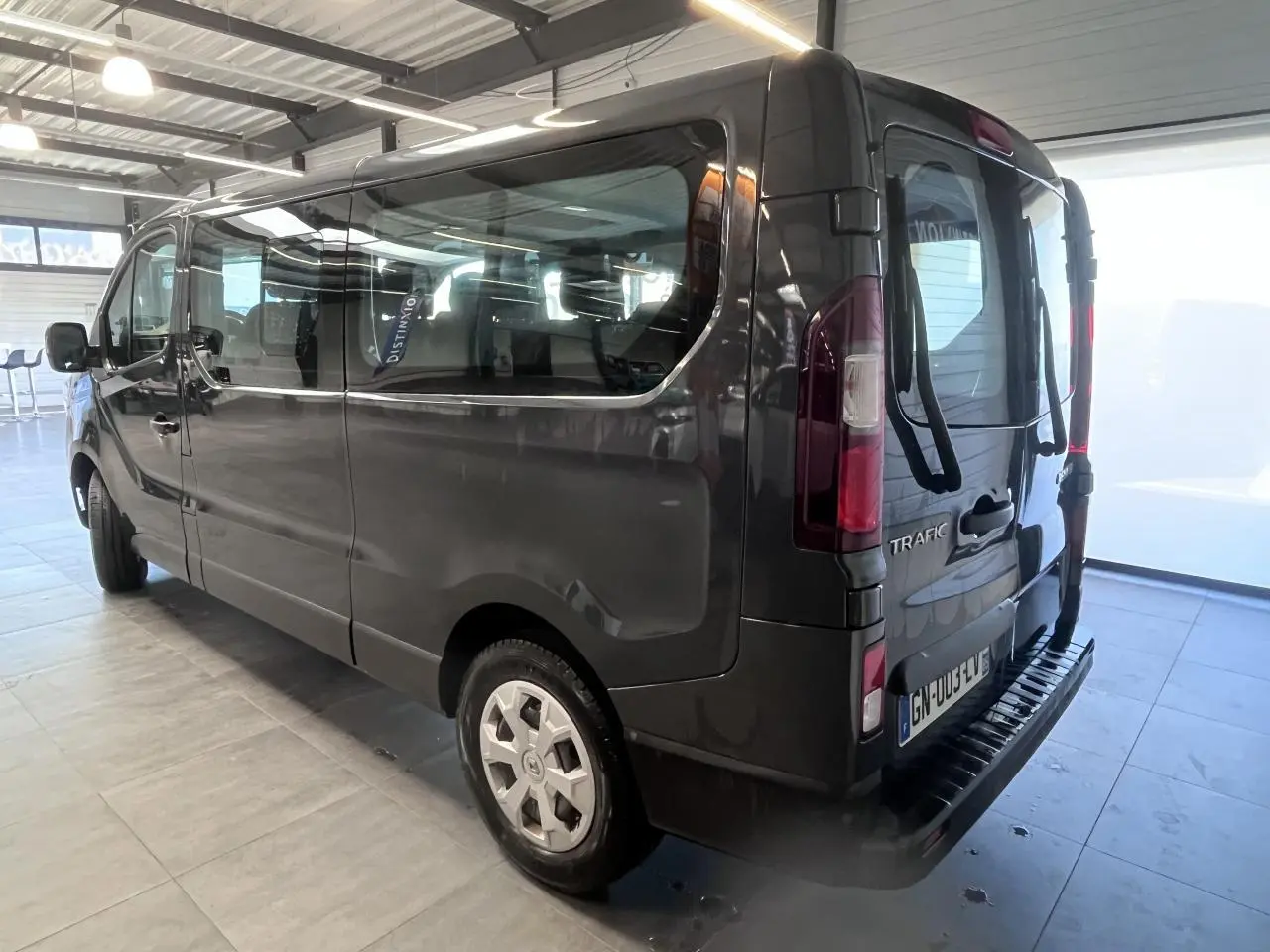 Vue 3/4 arrière droit du Renault Trafic Fourgon gris foncé avec portes arrière vitrées et porte-vélos installé.