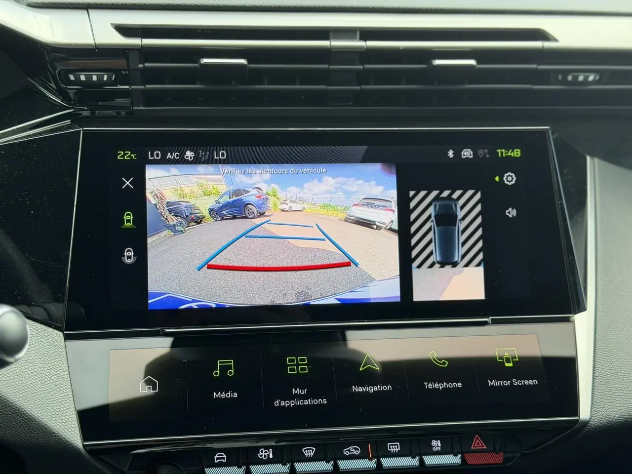 Écran tactile intérieur montrant la caméra de recul et l’aide au stationnement d’une Peugeot 308 gris Selenium.