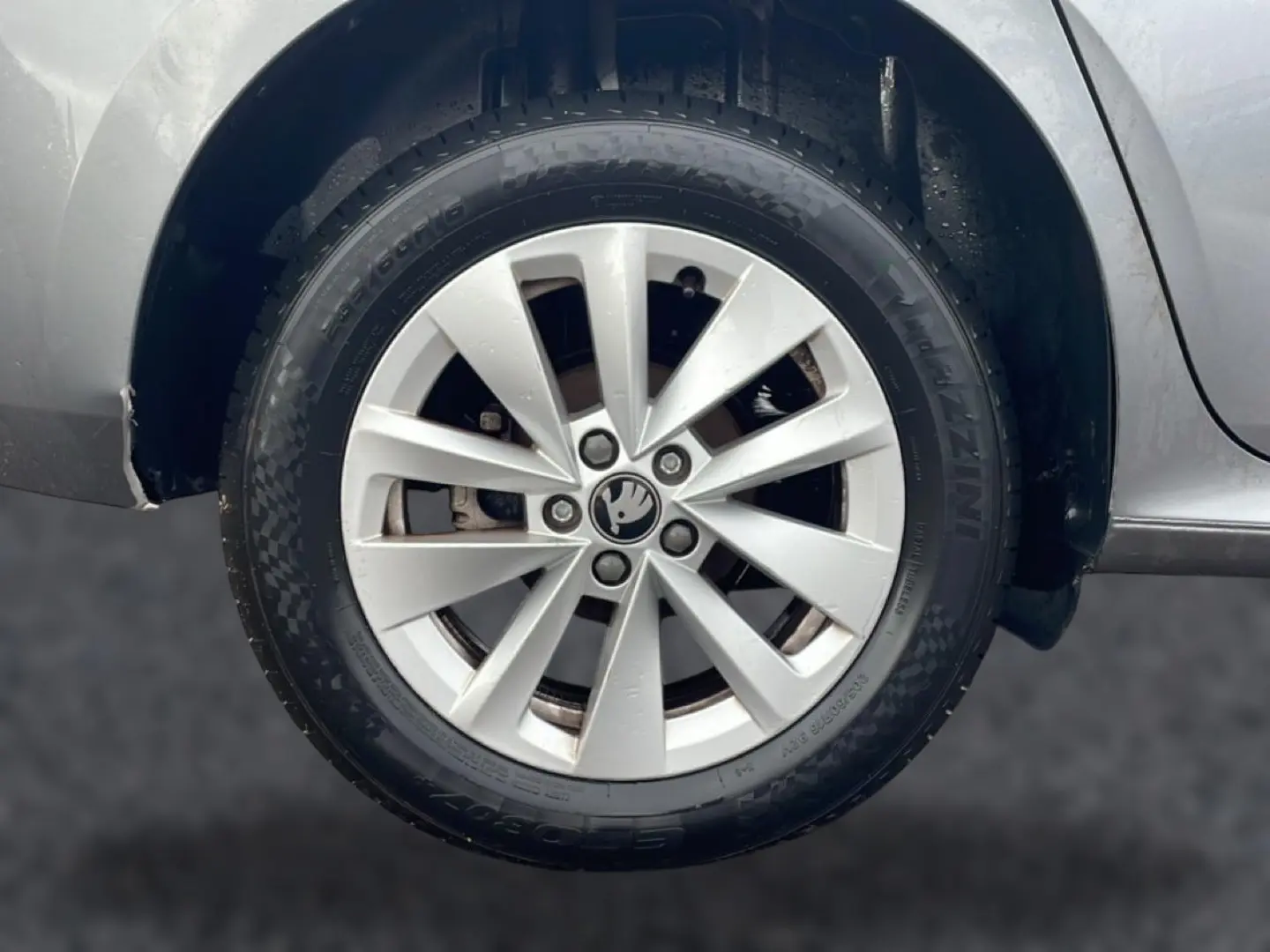 Gros plan sur la roue avant droite grise d'une Skoda Kamiq 2025 avec jante alu et logo au centre.