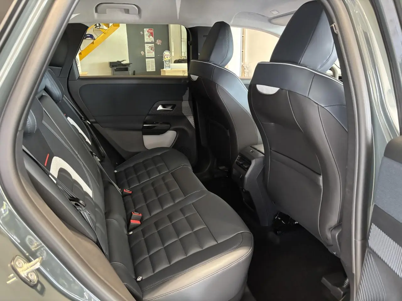 Vue intérieure côté gauche des sièges arrière en cuir noir avec inserts tissu clair du Citroën C5 Aircross vert 2026.