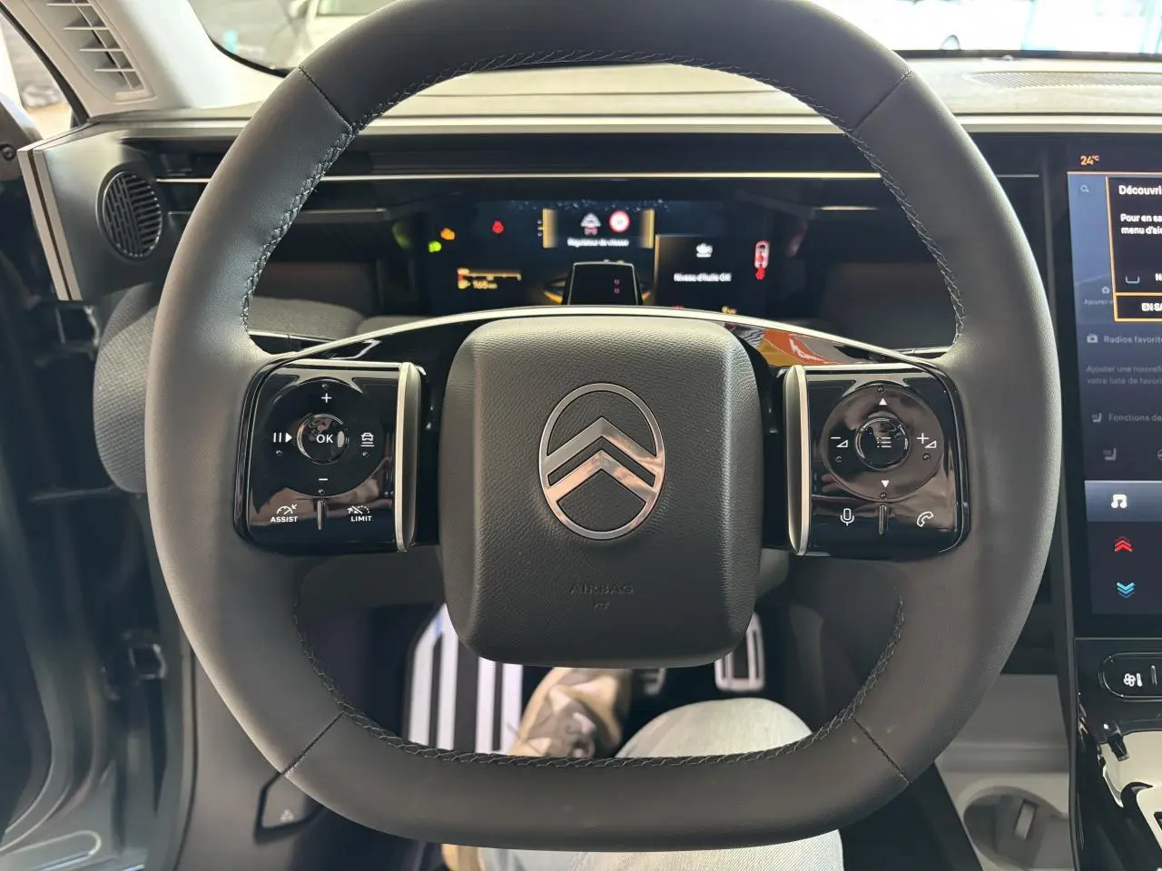Vue intérieure centrée sur le volant noir du Citroën C5 Aircross 2026 avec commandes tactiles et tableau de bord numérique.