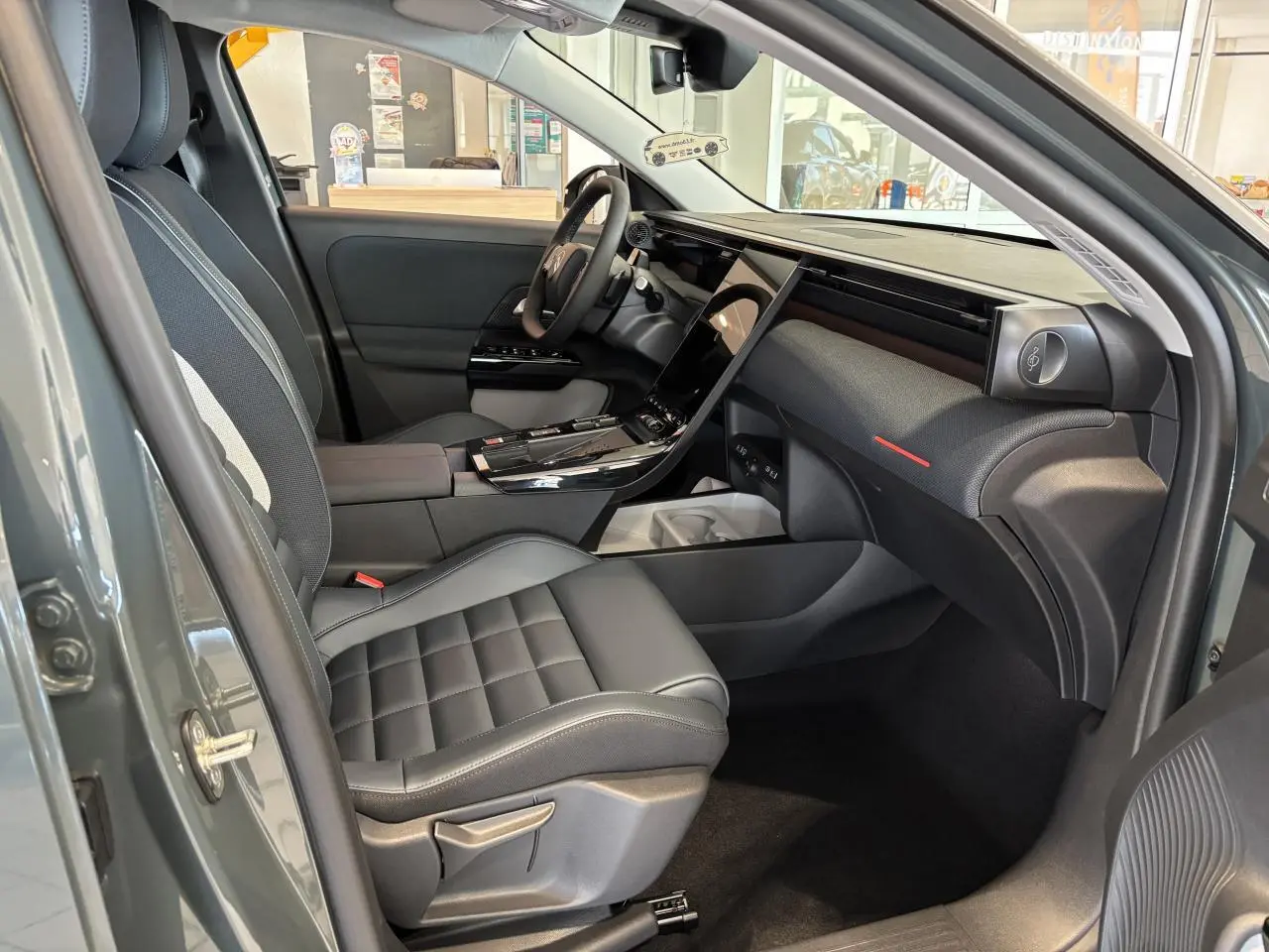 Vue intérieure côté passager avant du Citroën C5 Aircross vert, avec tableau de bord moderne et sièges noirs.
