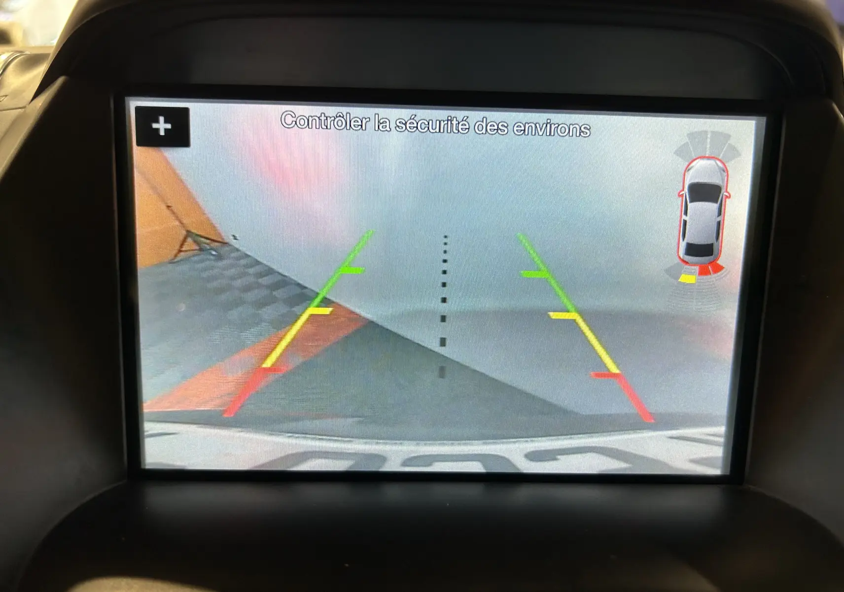 Écran de caméra de recul du Ford Kuga noir, vue arrière avec lignes de guidage colorées et capteurs d'obstacles.