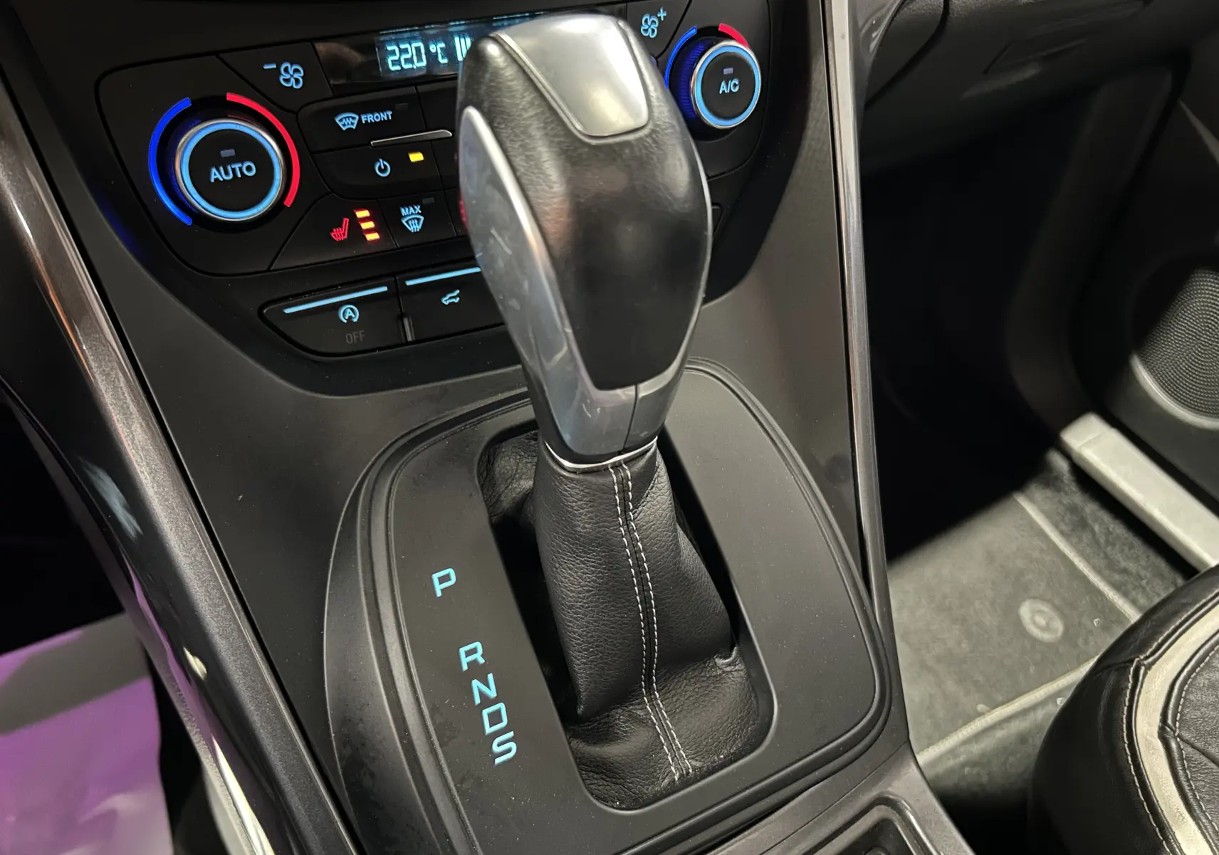Gros plan sur la commande de boîte automatique noire et console de climatisation du Ford Kuga TDCI 180 BVA Vignale 2017.