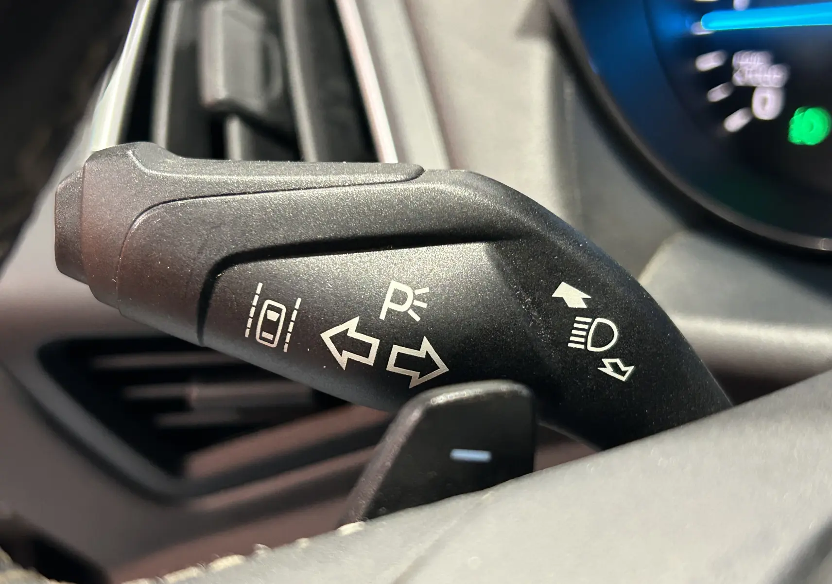Gros plan sur la manette de clignotant noire du Ford Kuga 2017, avec symboles blancs visibles sur fond intérieur gris.