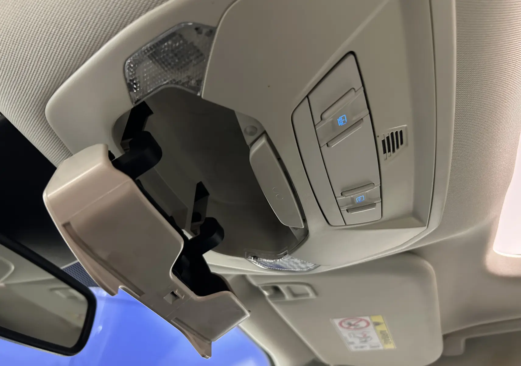 Intérieur du Ford Kuga 2017, vue en contre-plongée du rangement lunettes ouvert et des commandes de plafonnier beiges.