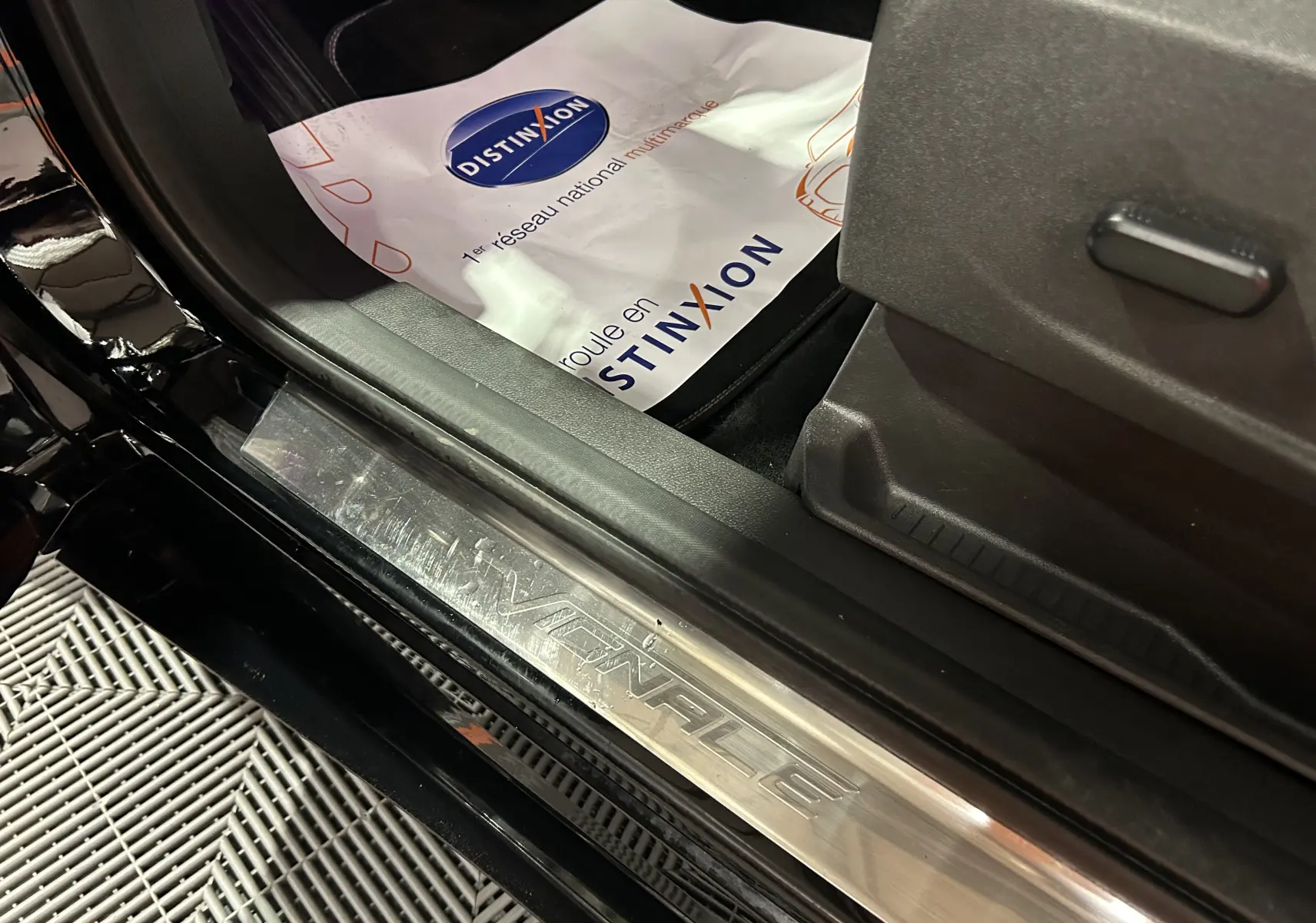 Gros plan sur la plaque de seuil de porte avant gauche noire du Ford Kuga Vignale, mettant en valeur le logo Vignale.