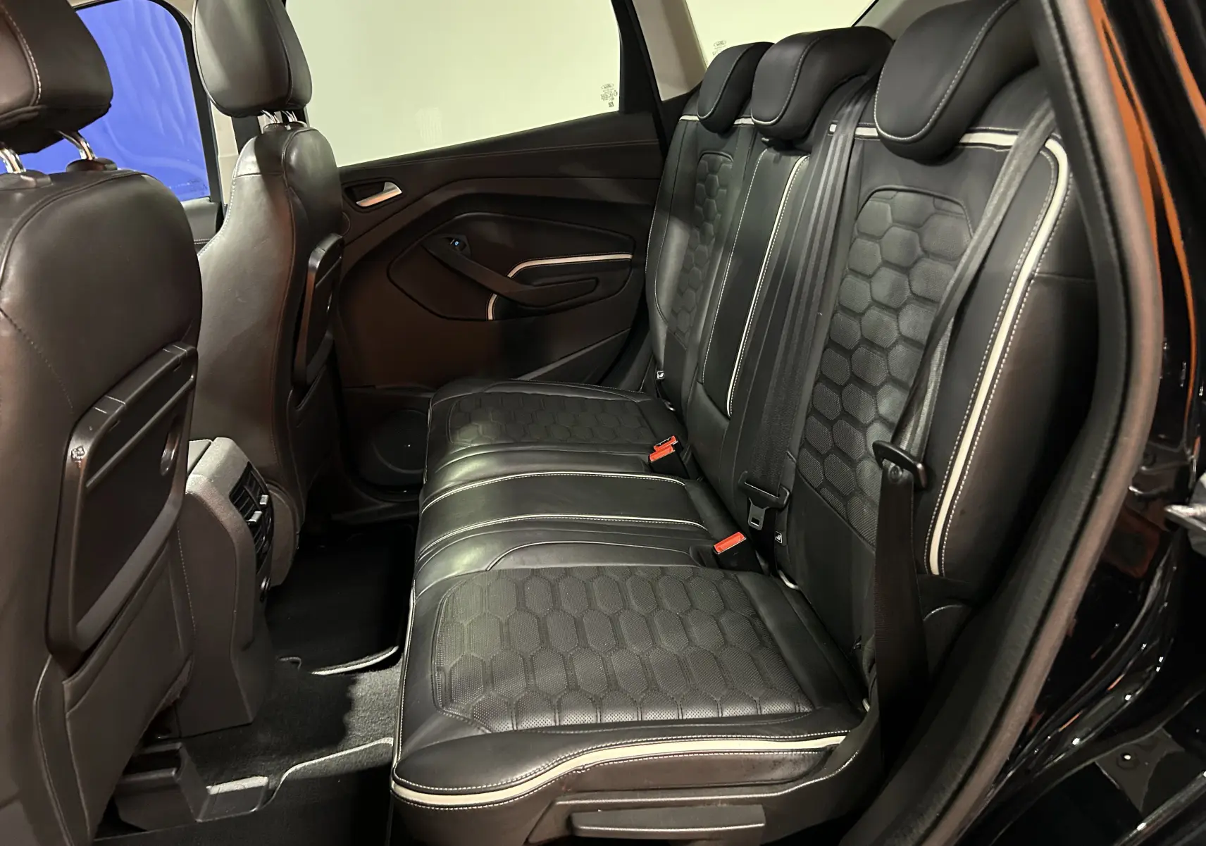 Vue intérieure côté droit des sièges arrière en cuir noir avec surpiqûres blanches du Ford Kuga Vignale 2017.
