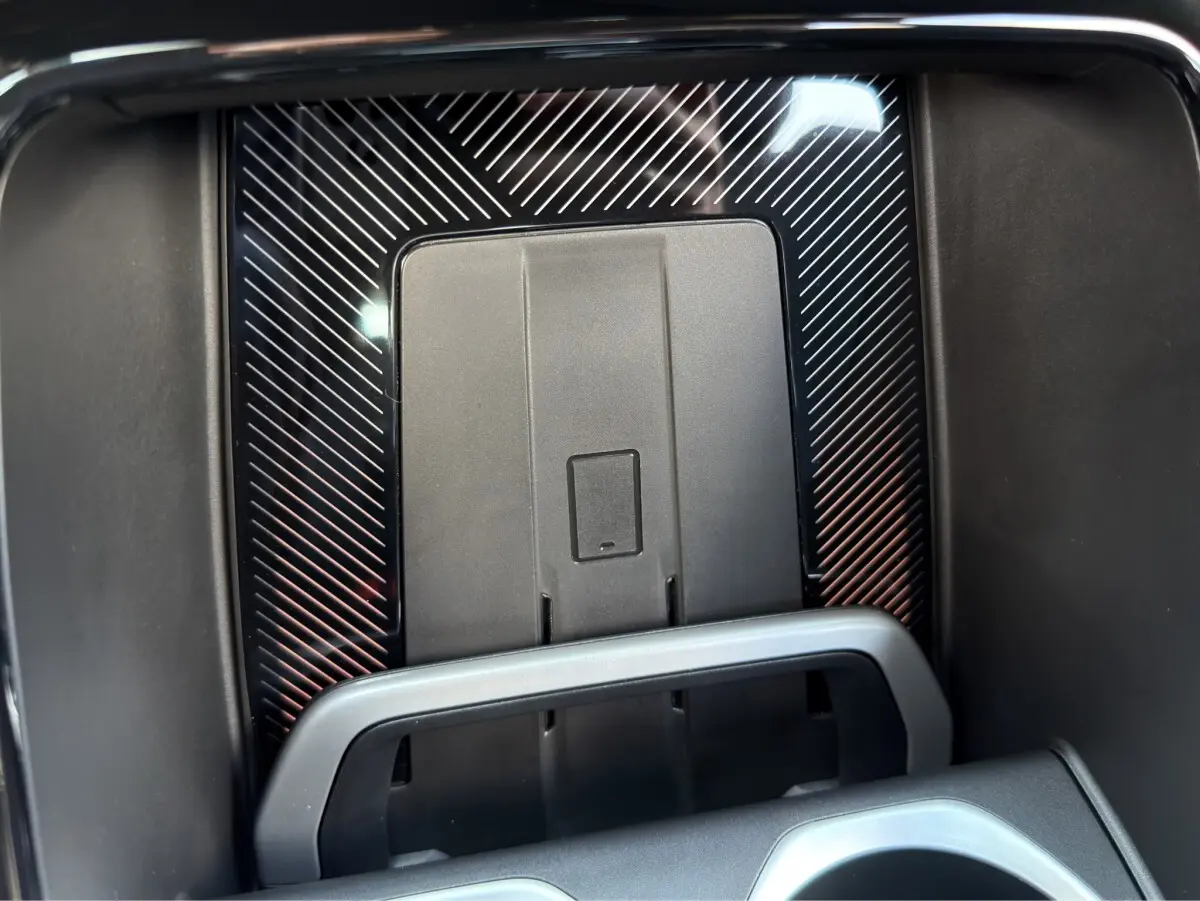 Gros plan sur le chargeur sans fil au centre de la console d’un BMW X1 blanc 2025 M SPORT.