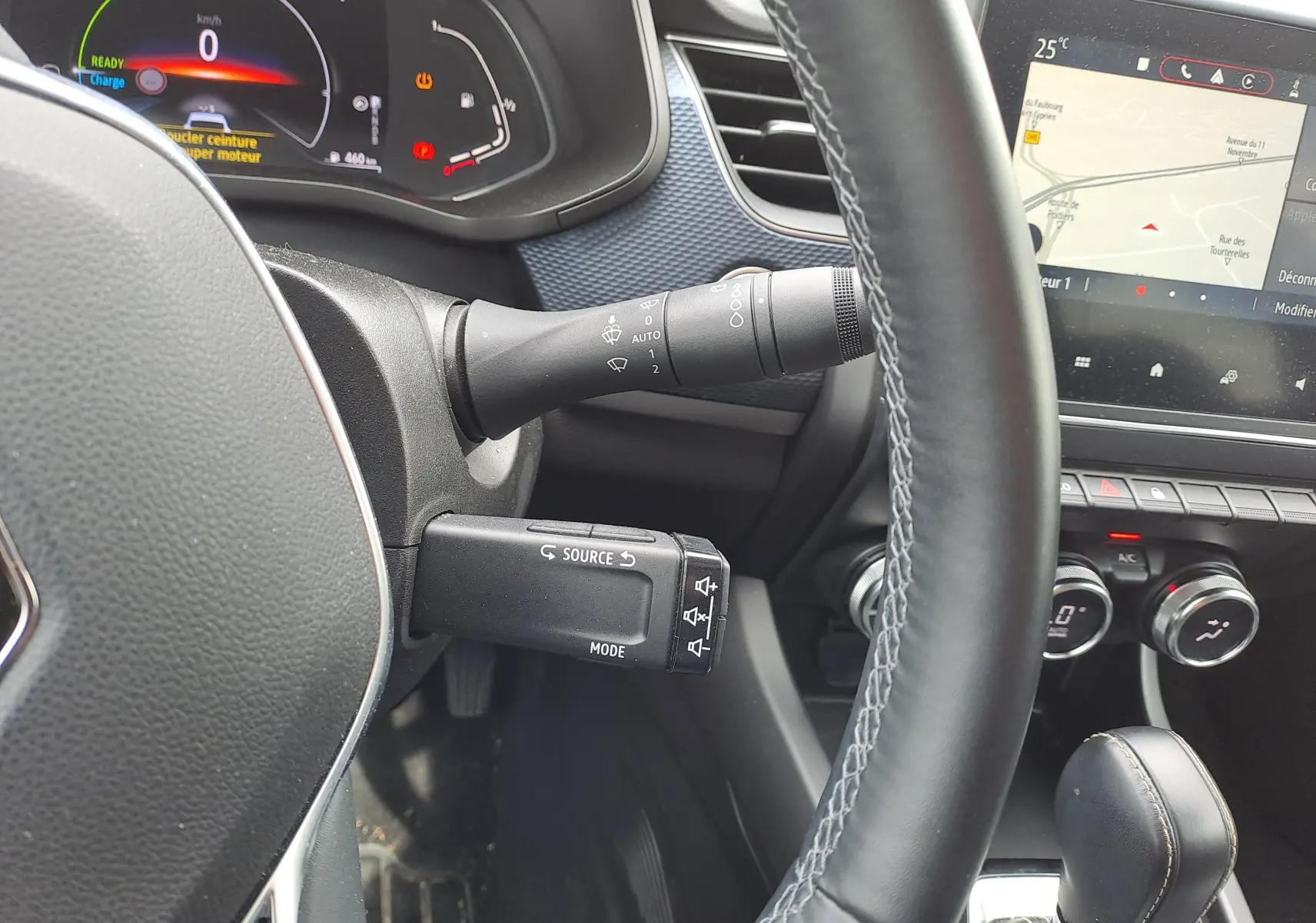 Gros plan sur le volant et le tableau de bord numérique du Renault Arkana 2023 avec commandes au volant et écran tactile.