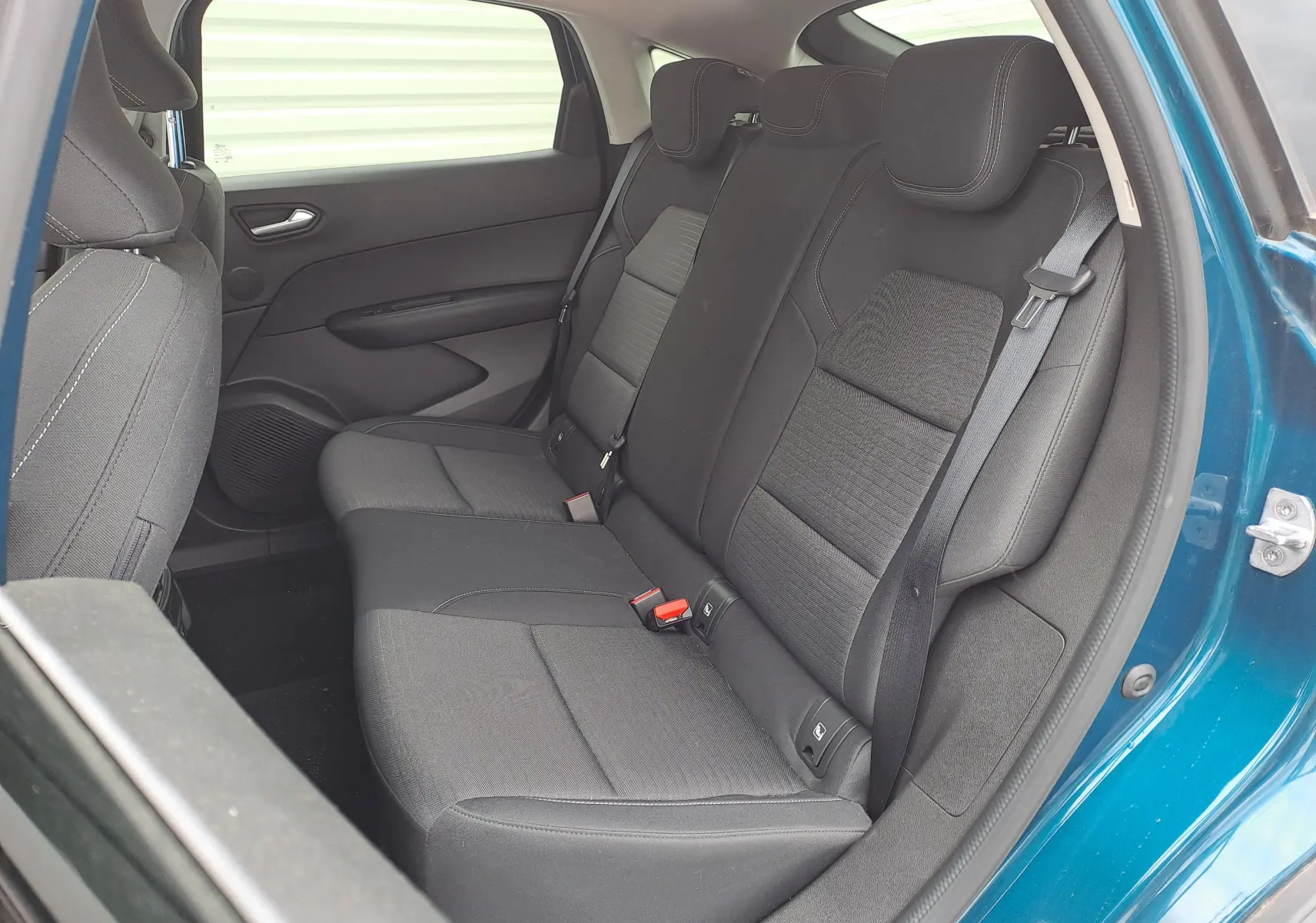 Vue intérieure côté droit des sièges arrière en tissu noir du Renault Arkana bleu Zanzibar métal 2023.
