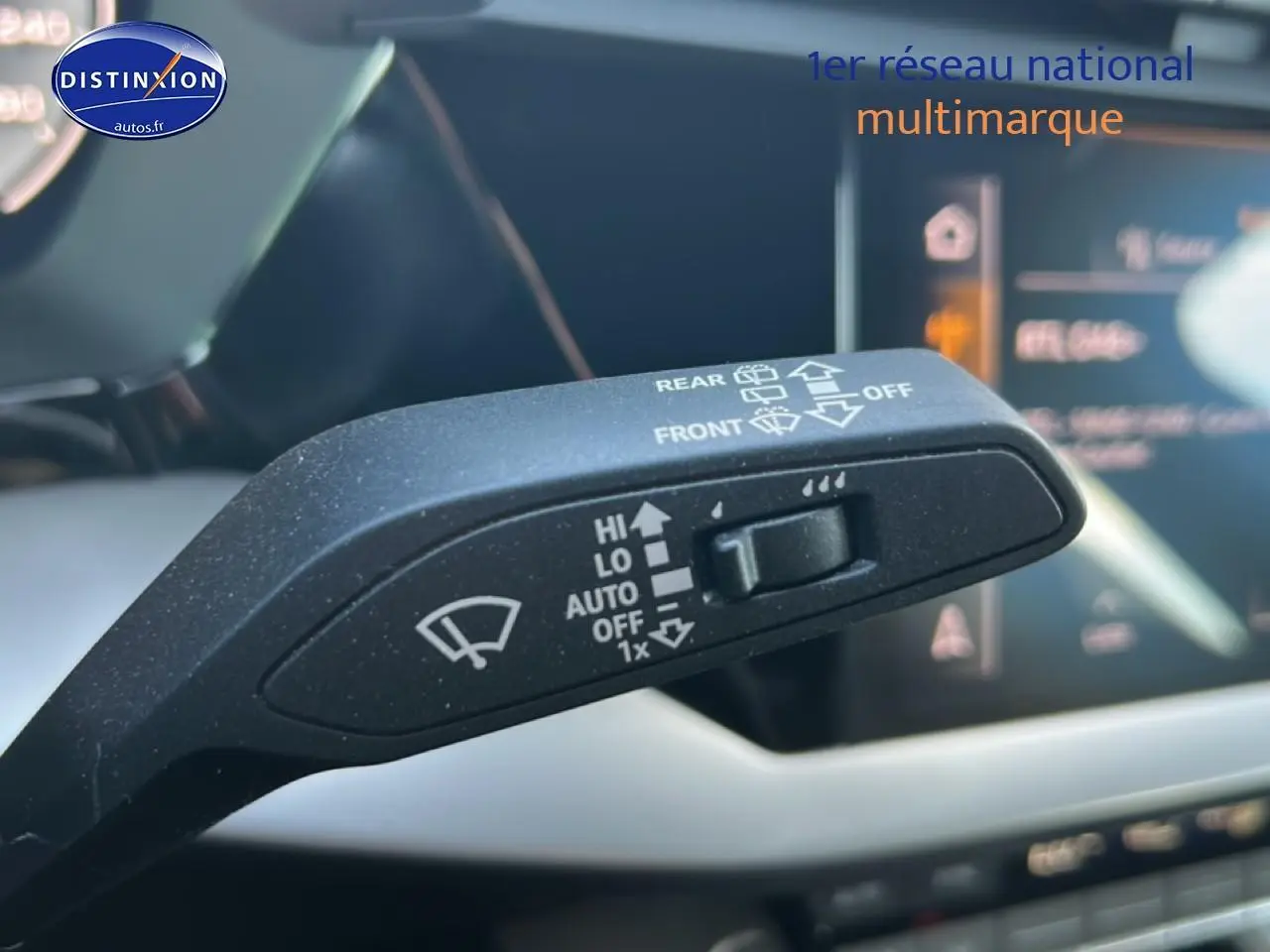 Gros plan sur la commande d'essuie-glace noire dans l'habitacle de l'Audi A3 Sportback 2024 avec tableau de bord numérique flou.