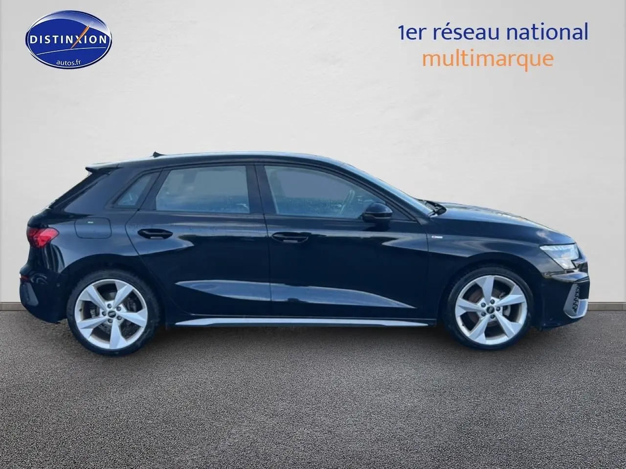 Profil droit d'une Audi A3 Sportback noire 2024 avec jantes alliage 5 branches et finition S line.