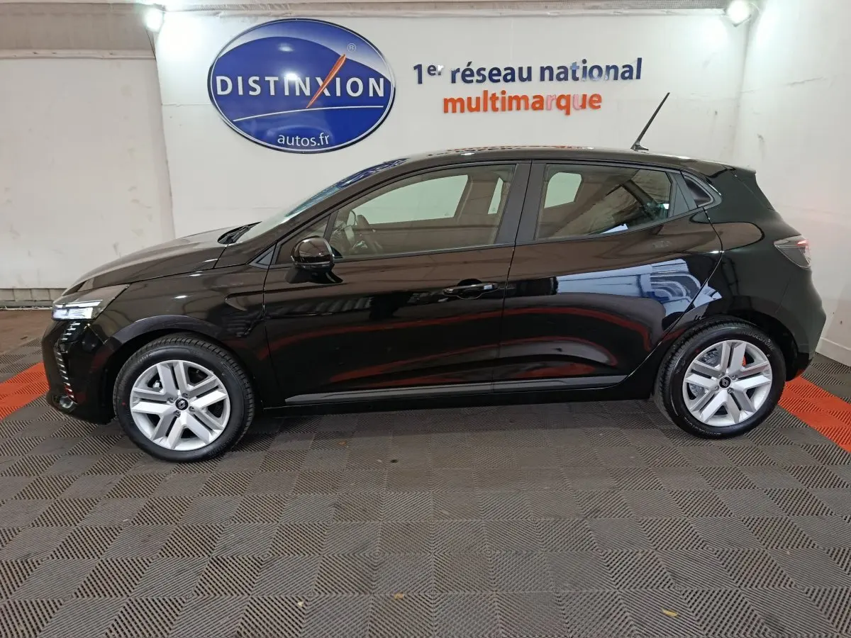 Profil côté gauche d'une Renault Clio Evolution Blue dCi 100 noire, vue en intérieur avec éclairage doux et jantes alliage.