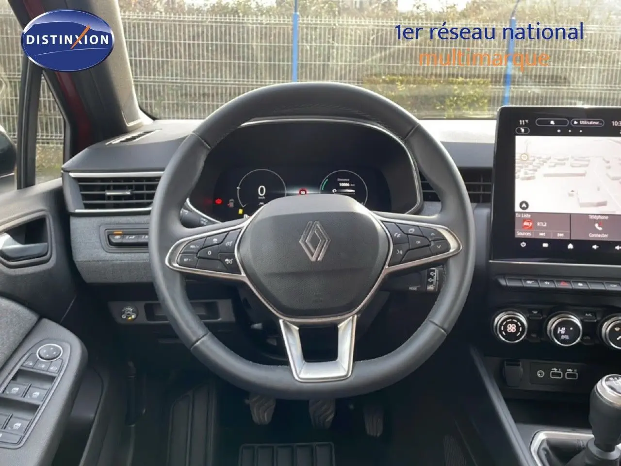 Vue intérieure centrée sur le volant multifonction de la Renault Clio 2025, avec tableau de bord numérique et écran tactile.