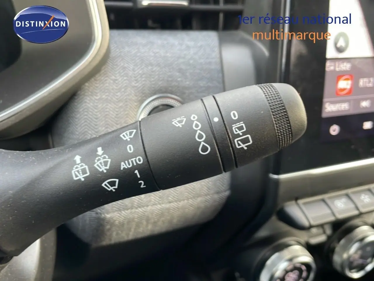 Gros plan sur la manette d’essuie-glace noire dans l’habitacle de la Renault Clio rouge Désir Métal 2025.