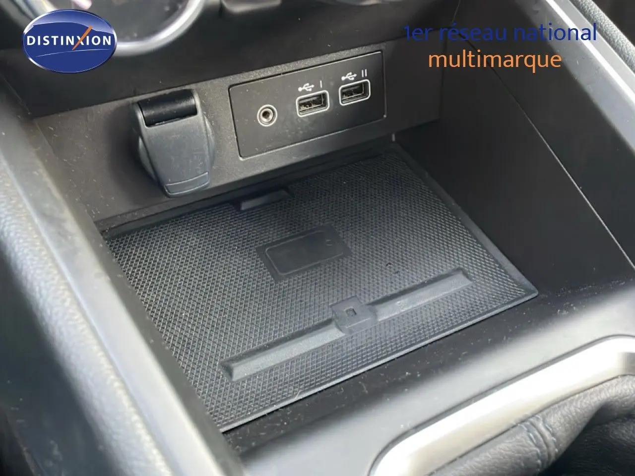 Gros plan sur la console centrale de la Renault Clio rouge Désir Métal 2025, montrant les ports USB et prise auxiliaire.