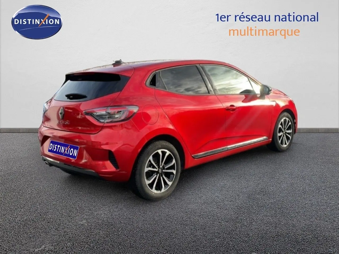 Vue 3/4 arrière droite d'une Renault Clio rouge Désir Métal, avec jantes alliage et vitres teintées.