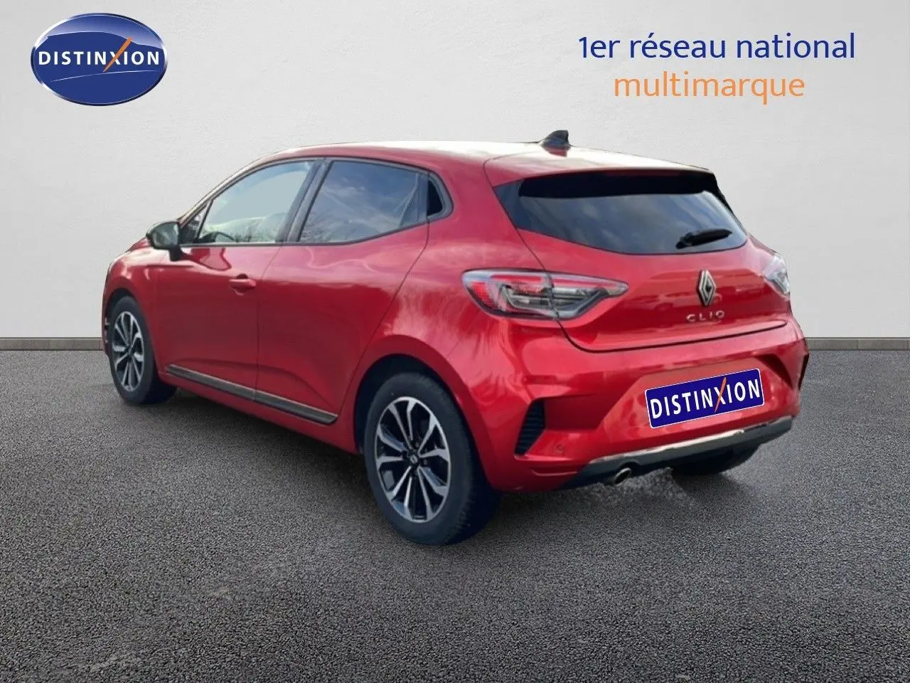 Vue 3/4 arrière droite d'une Renault Clio rouge Désir Métal, avec jantes alliage et vitres teintées.