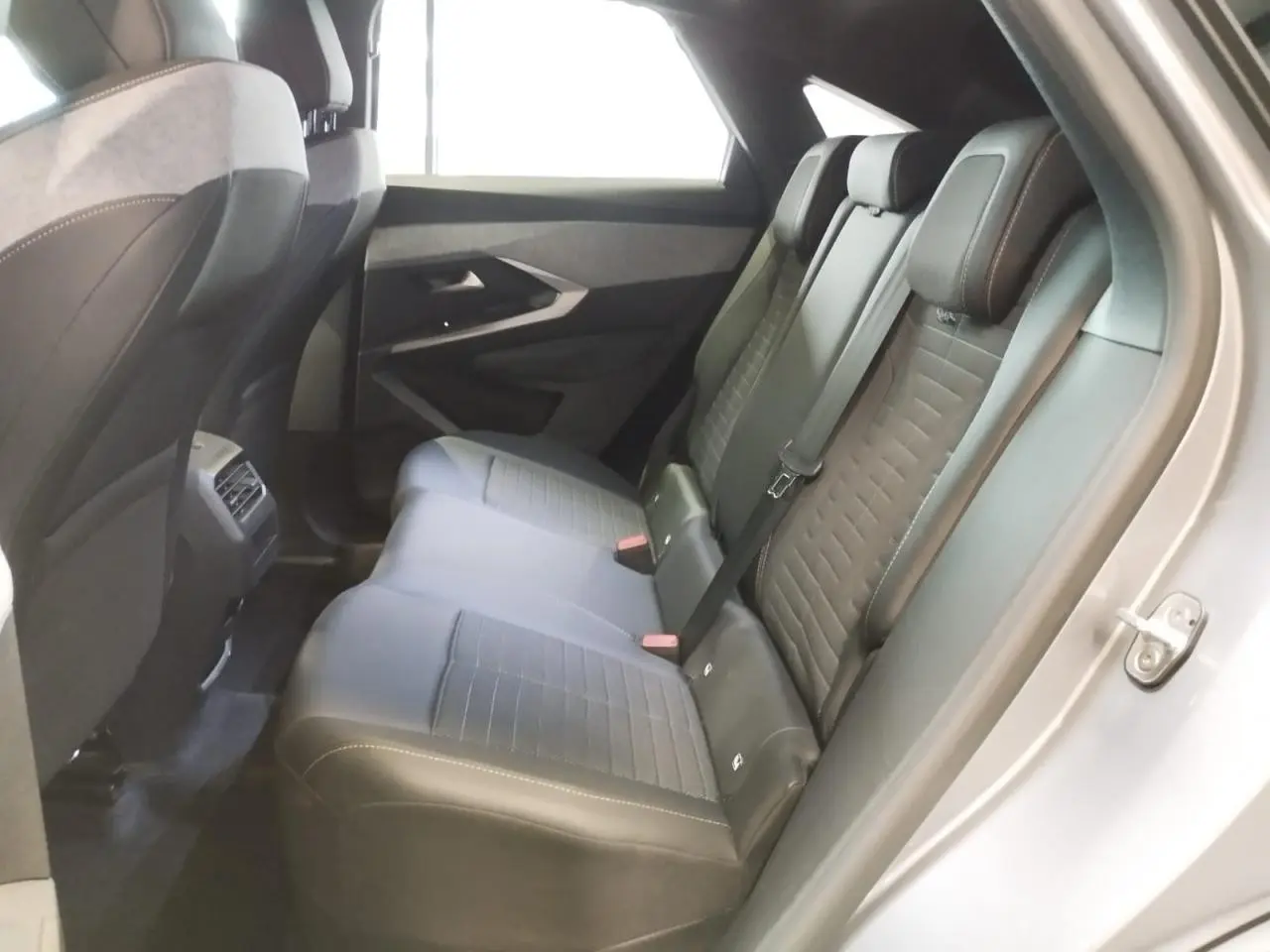 Vue intérieure côté droit des sièges arrière gris foncé avec surpiqûres claires du Peugeot 3008 2024 hybride.