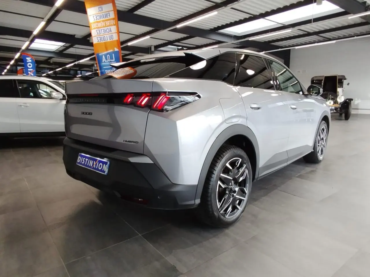 Peugeot 3008 gris Artense vue 3/4 arrière droit en intérieur, feux arrière LED 3 griffes allumés.
