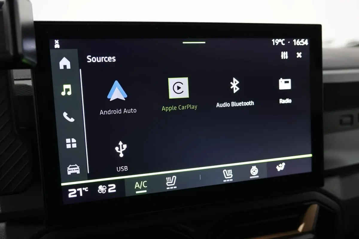 Écran tactile central du tableau de bord du Dacia Duster 2024 affichant les options multimédia et climatisation.