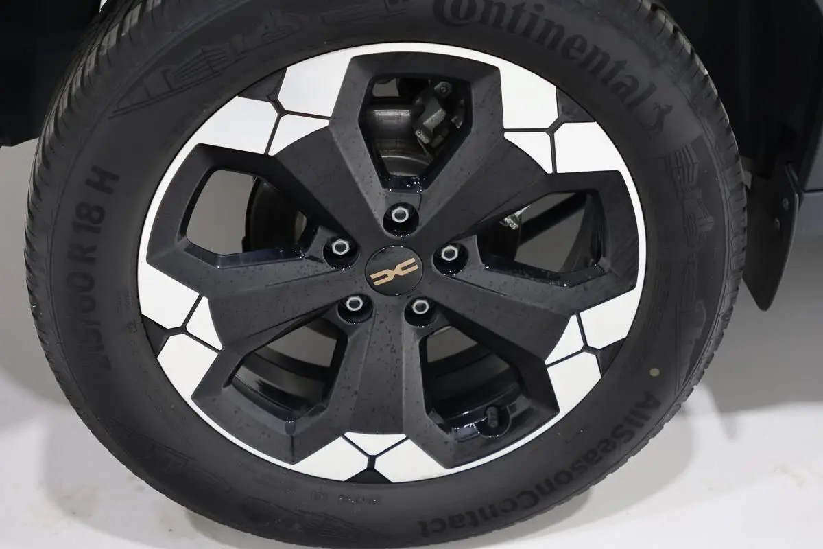 Gros plan sur la jante noire et blanche du Dacia Duster TCE 130 4x4 Extreme couleur Sandstone, pneus Continental.