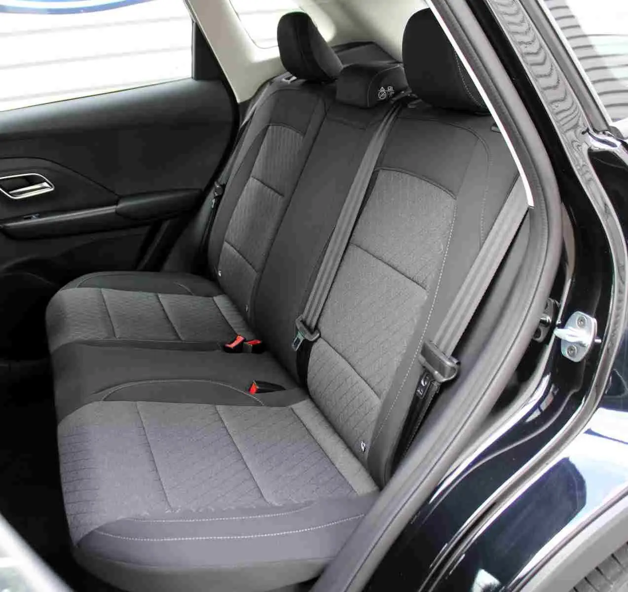 Gros plan sur l’inscription ZS Hybrid+ en chrome sur la carrosserie noire Pebble Black Metal du MG ZS 2026.