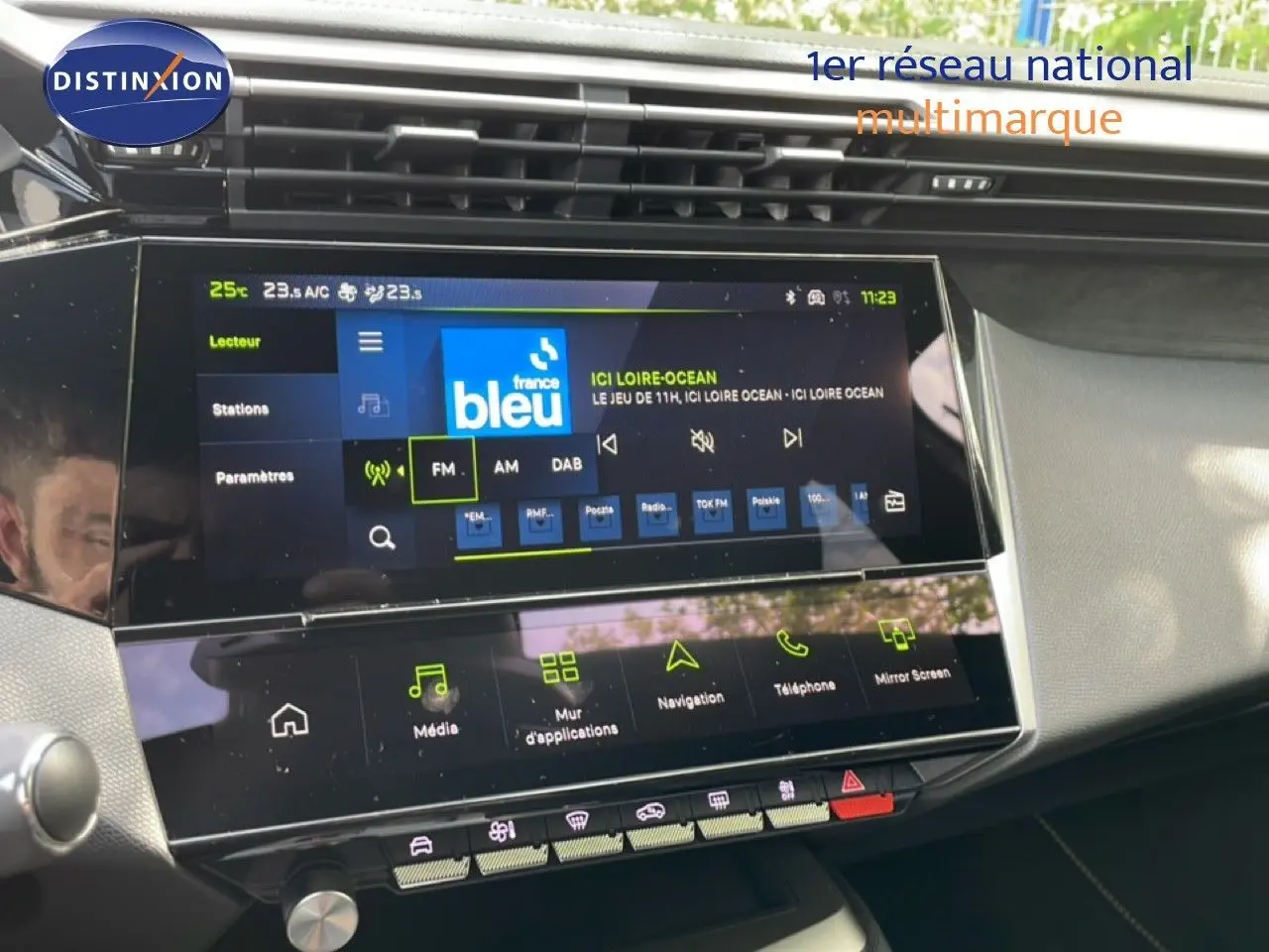 Vue rapprochée de l’écran tactile central du tableau de bord de la Peugeot 308 gris Artense, affichant la radio FM.