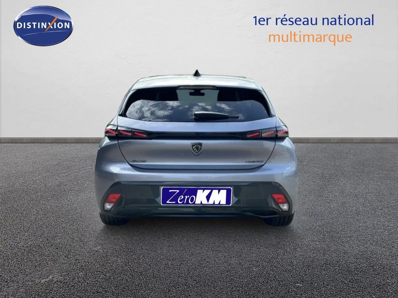 Vue arrière d'une Peugeot 308 1.2 Hybrid gris Artense métal, avec feux LED et logo central sur fond clair.