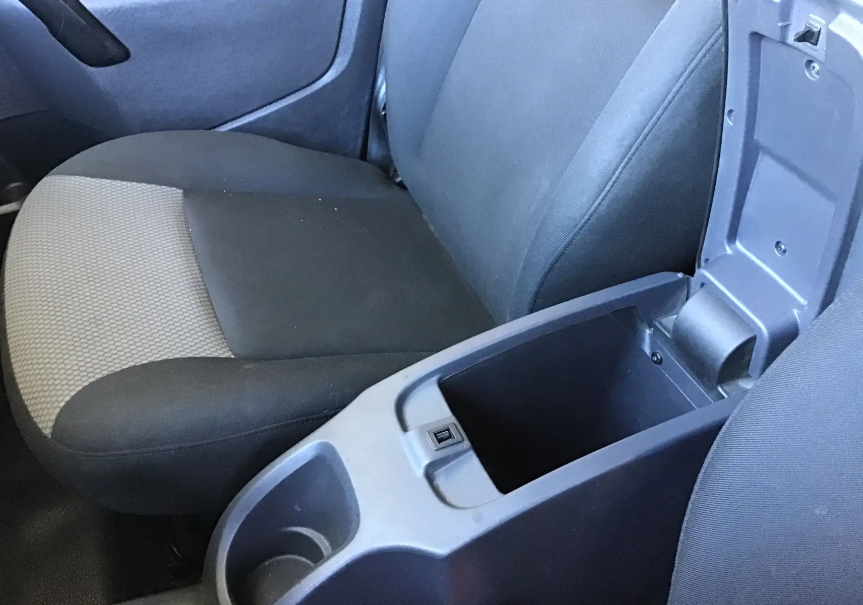 Vue rapprochée de l’intérieur du Renault Kangoo 2021, siège passager gris et console centrale ouverte noire.