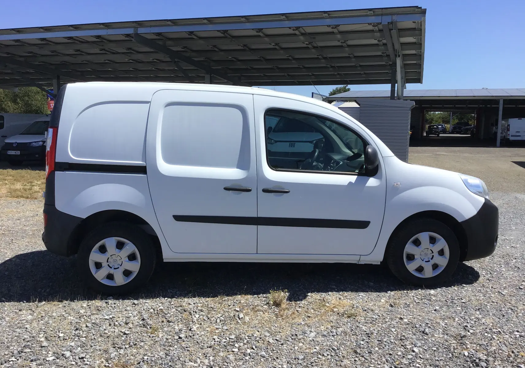 Vue latérale droite d’un utilitaire Renault Kangoo blanc 2021 avec portes latérales pleines et jantes acier.