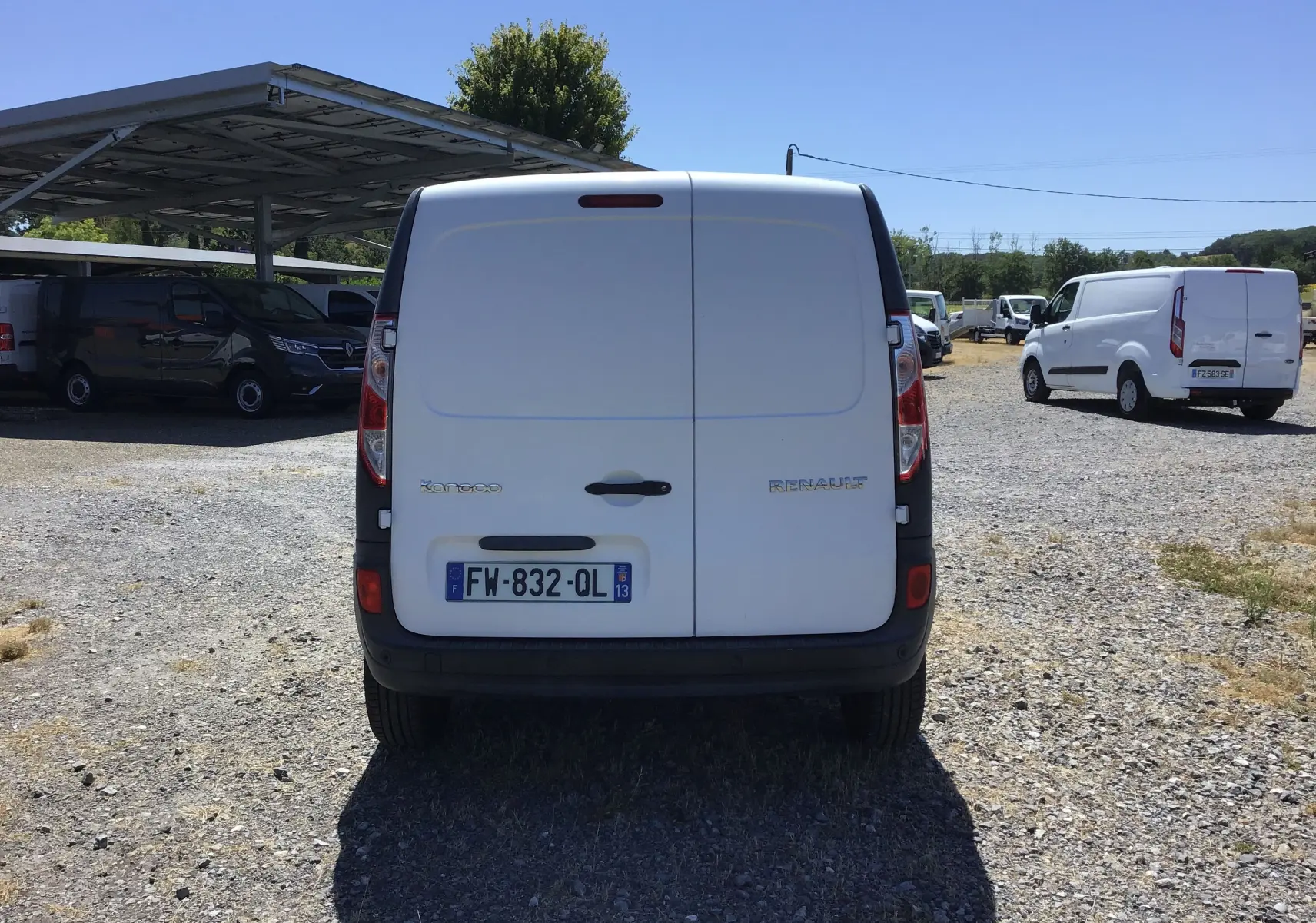 Vue arrière d’un Renault Kangoo blanc 2021, fourgon utilitaire avec portes battantes et plaque d’immatriculation française.