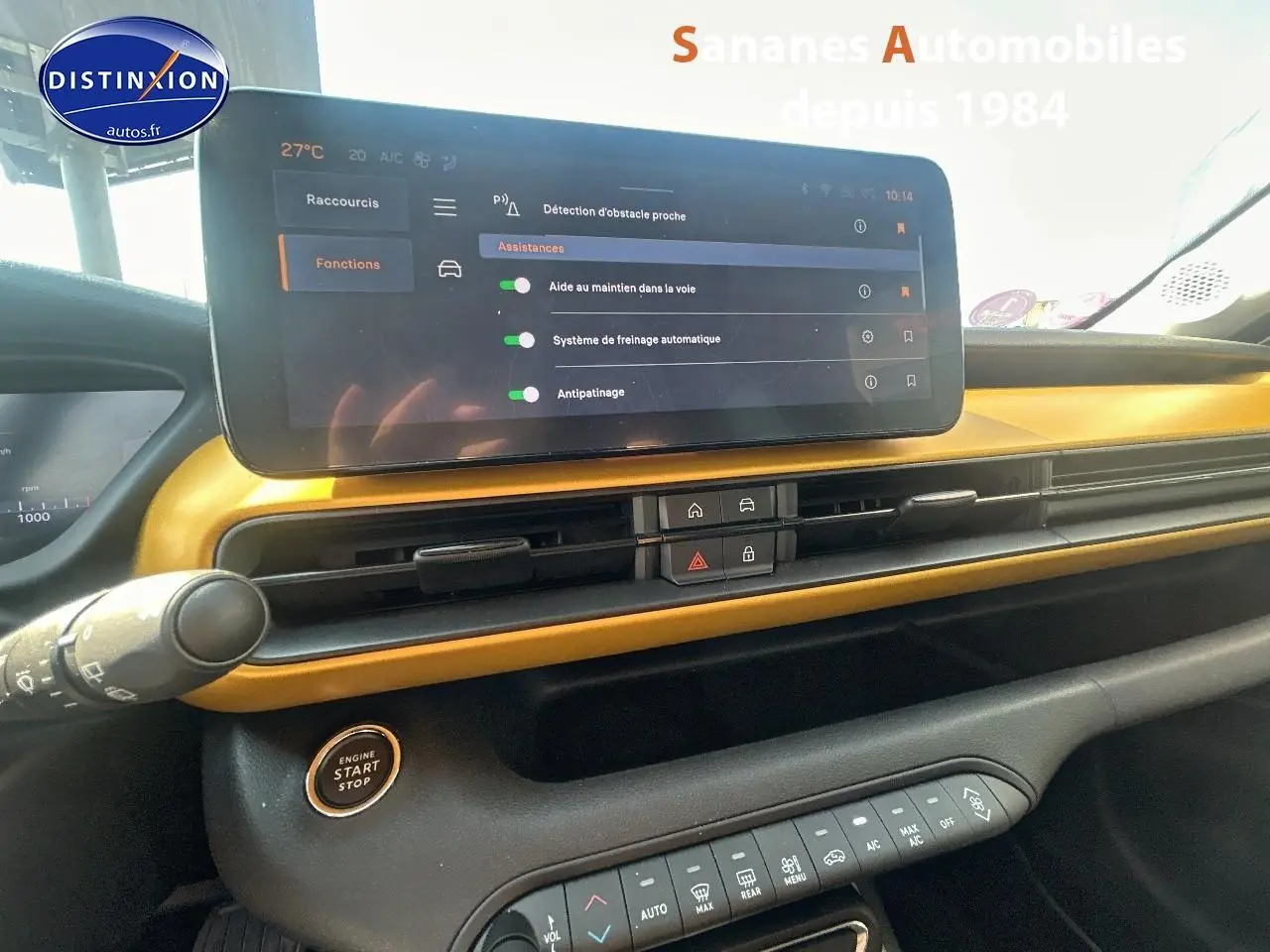 Tableau de bord intérieur du Jeep Avenger jaune foncé, avec écran tactile affichant les aides à la conduite.