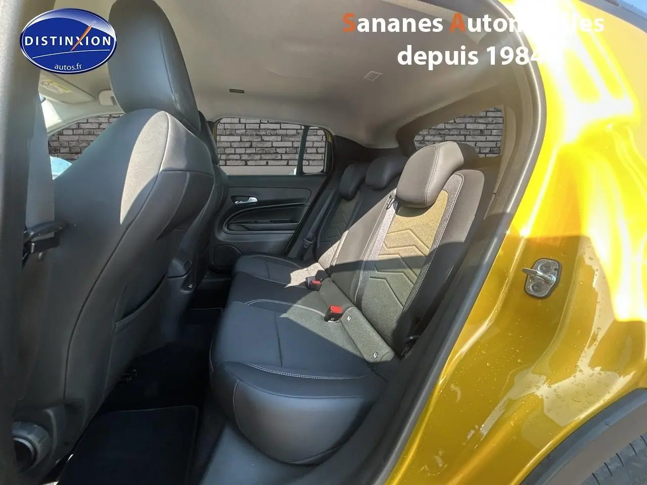 Vue intérieure arrière côté droit du Jeep Avenger jaune foncé, montrant les sièges arrière en tissu et cuir noir.