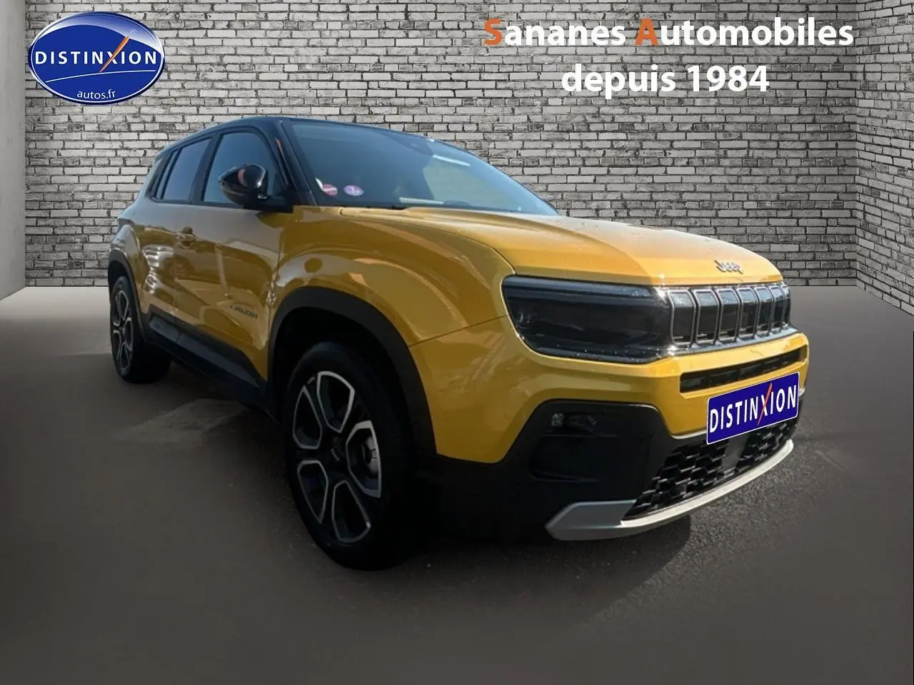 Jeep Avenger jaune foncé en 3/4 avant droit avec calandre gloss black et jantes distinctives.